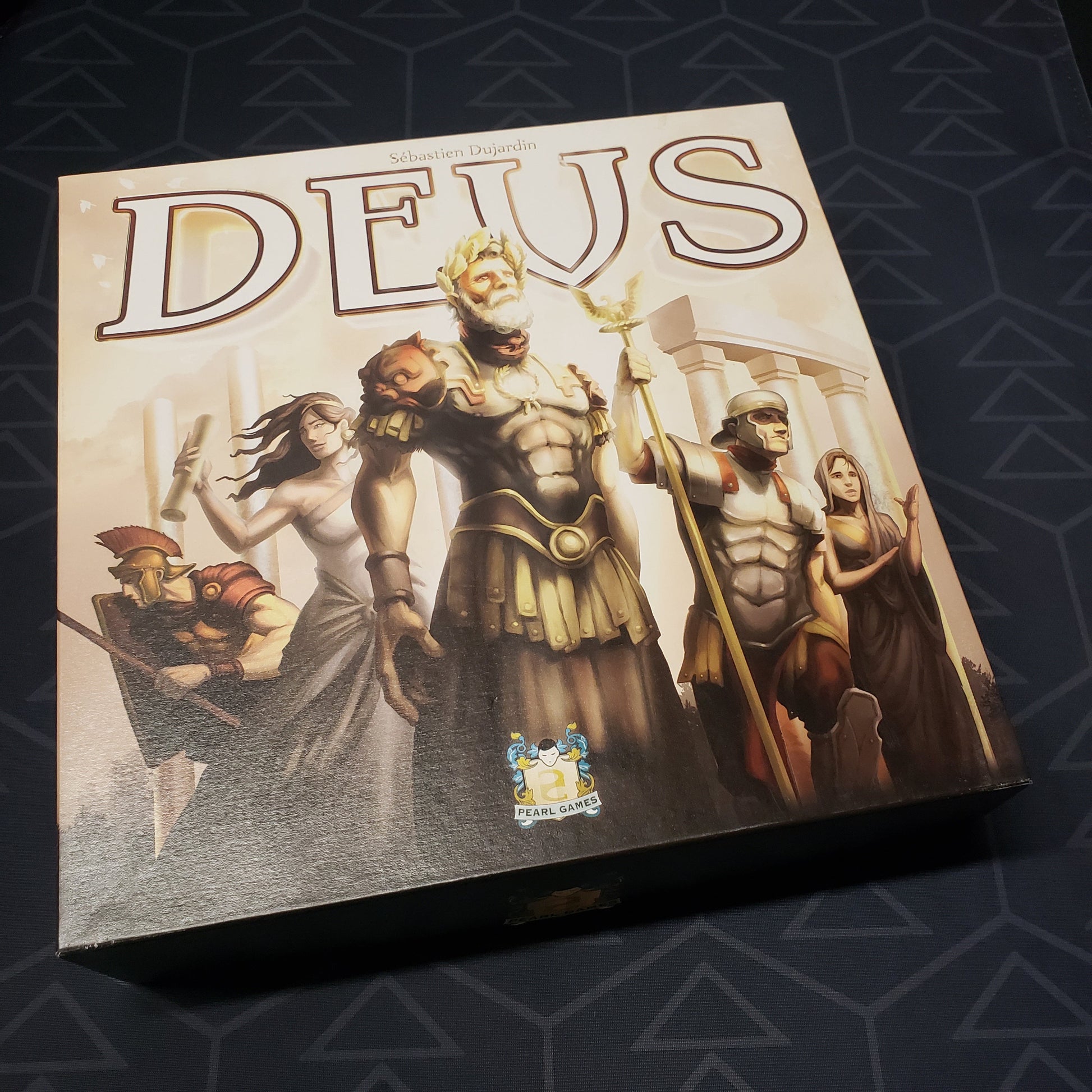 Image shows the front cover of the box of the Deus board game