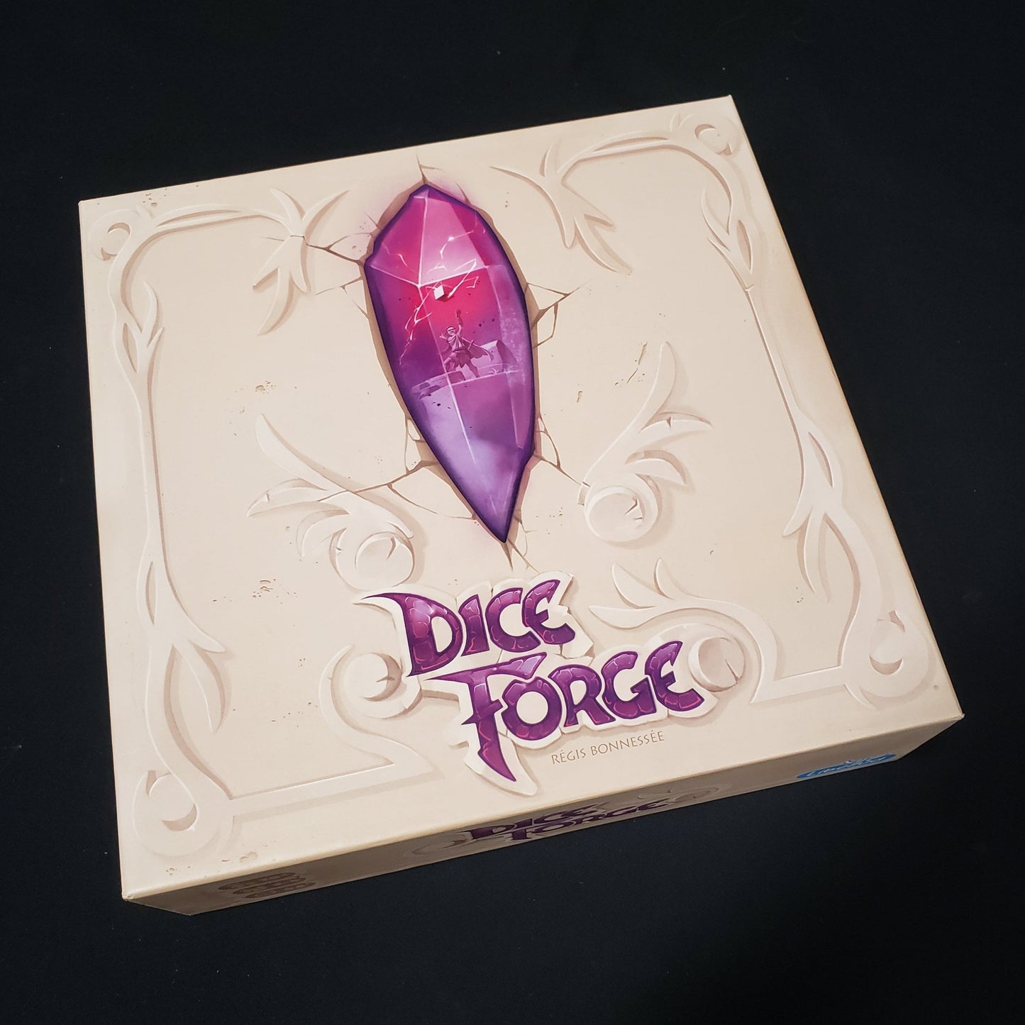 Image shows the front cover of the box of the Dice Forge board game