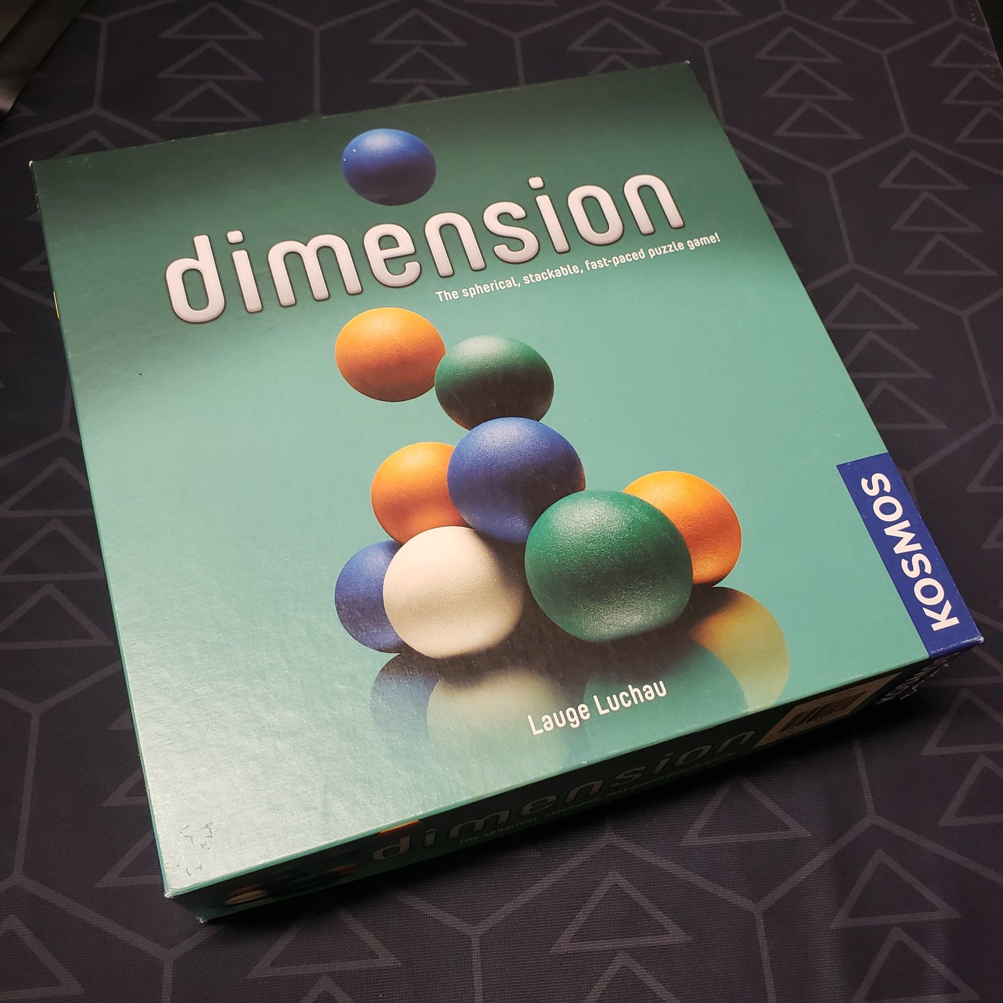Image shows the front cover of the box of the Dimension board game