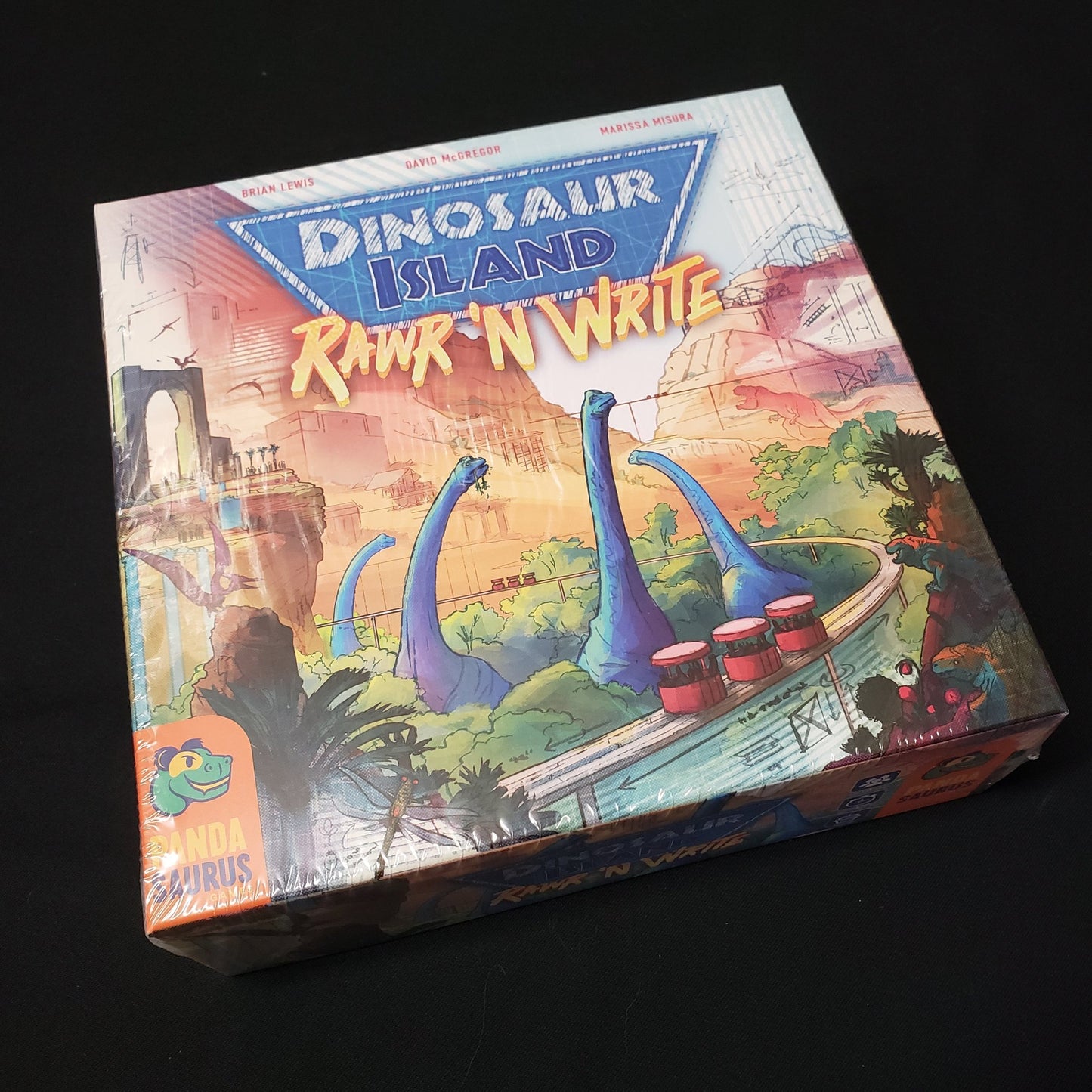 Image shows the front cover of the box of the Dinosaur Island: Rawr 'N Write board game