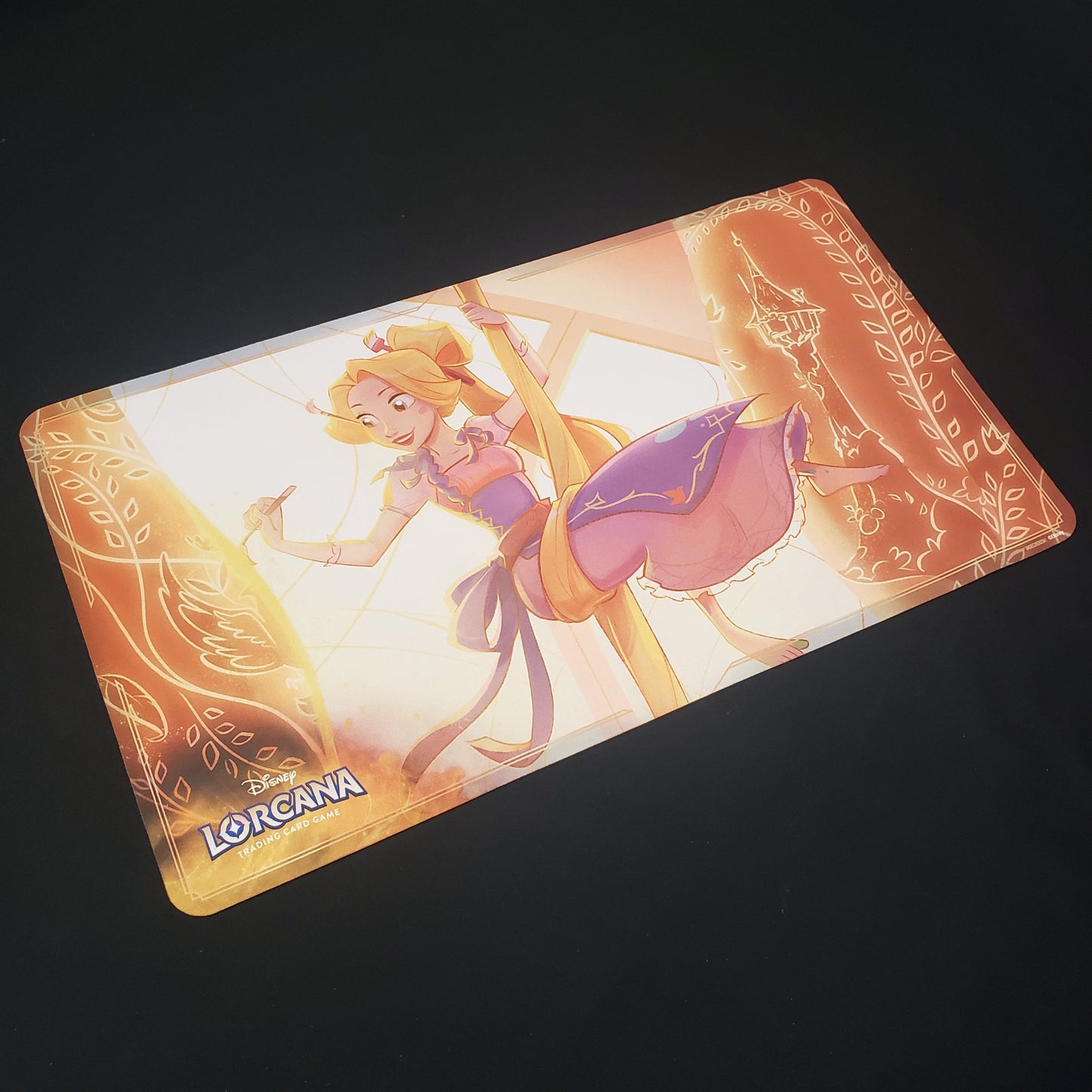 Image shows a playmat featuring Ursula's Return: Rapunzel art for the Disney Lorcana card game