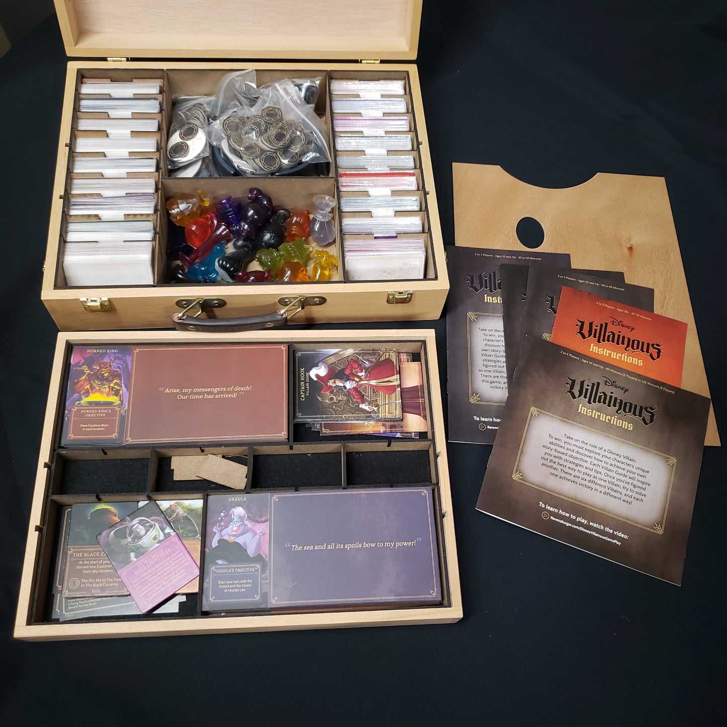 Image shows the contents of a Disney Villainous card game collection inside a custom wooden box