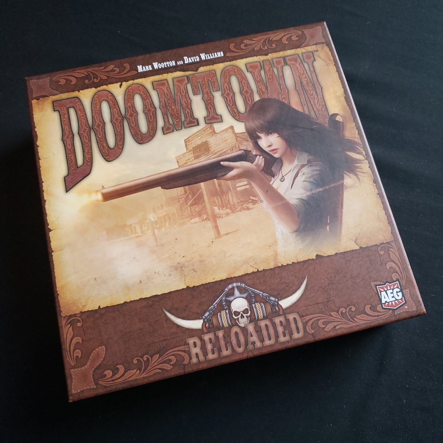 Image shows the front cover of the box of the Doomtown: Reloaded card game