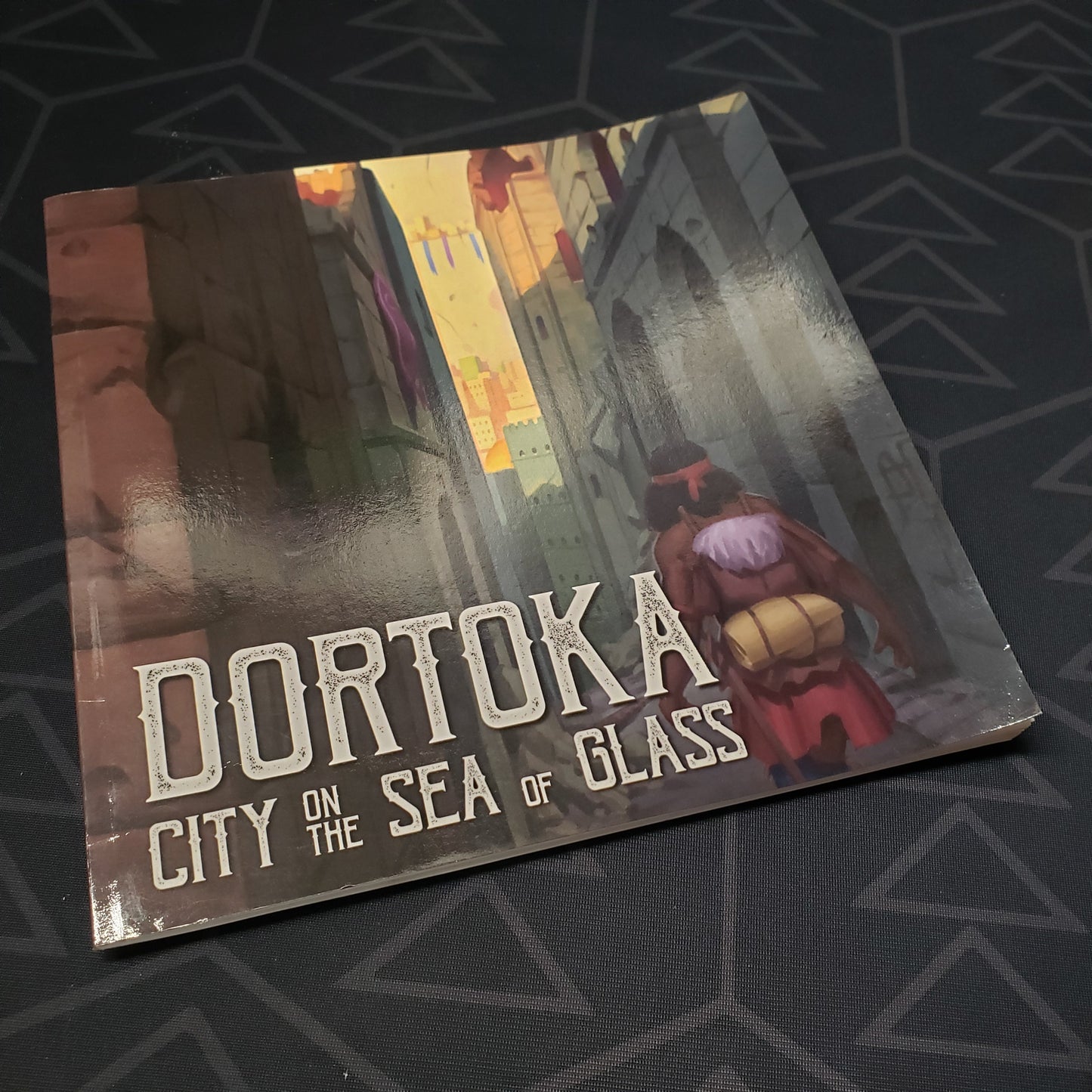 Image shows the front cover of the Dortoka: City on the Sea of Glass roleplaying game book