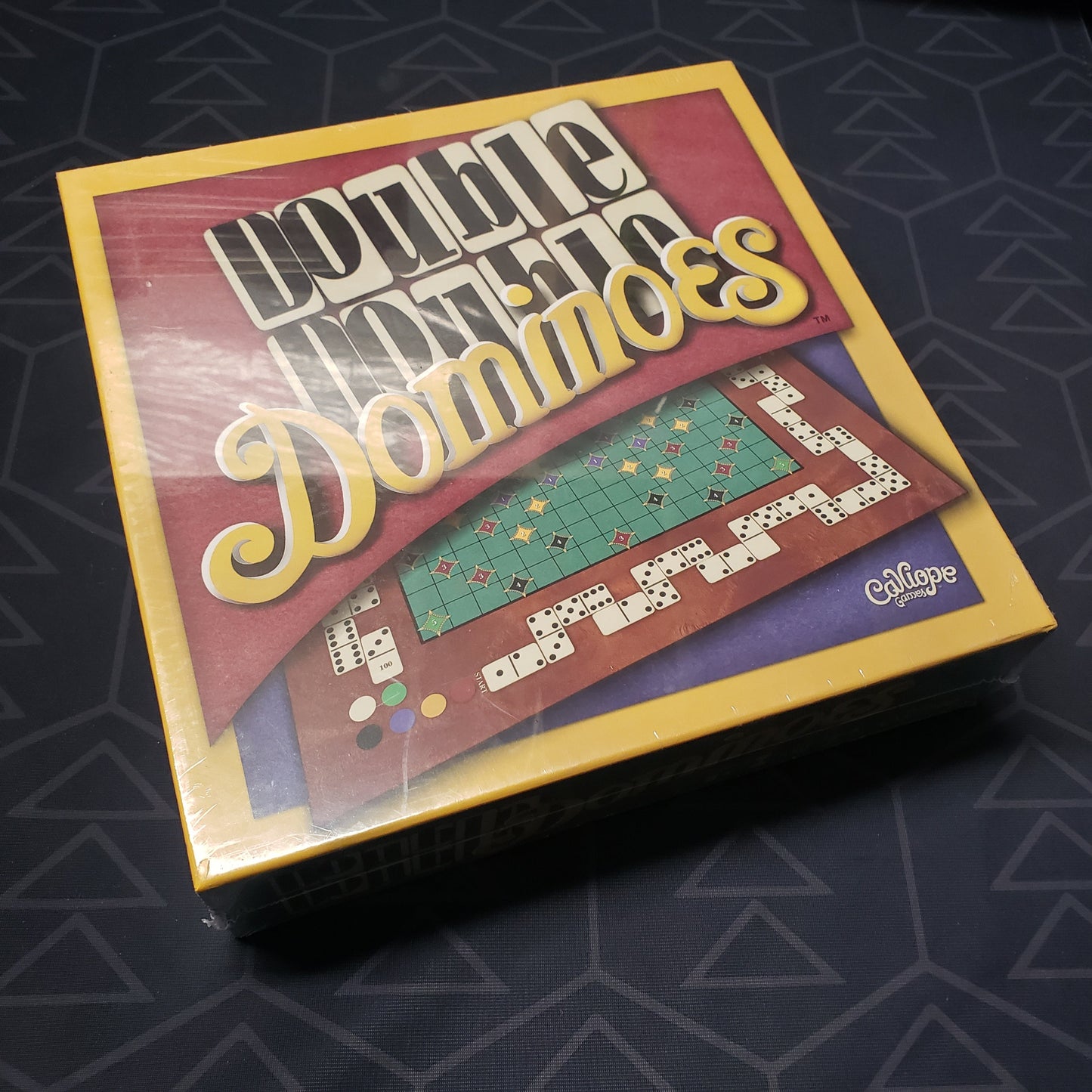 Image shows the front cover of the box for the Double Double Dominoes board game