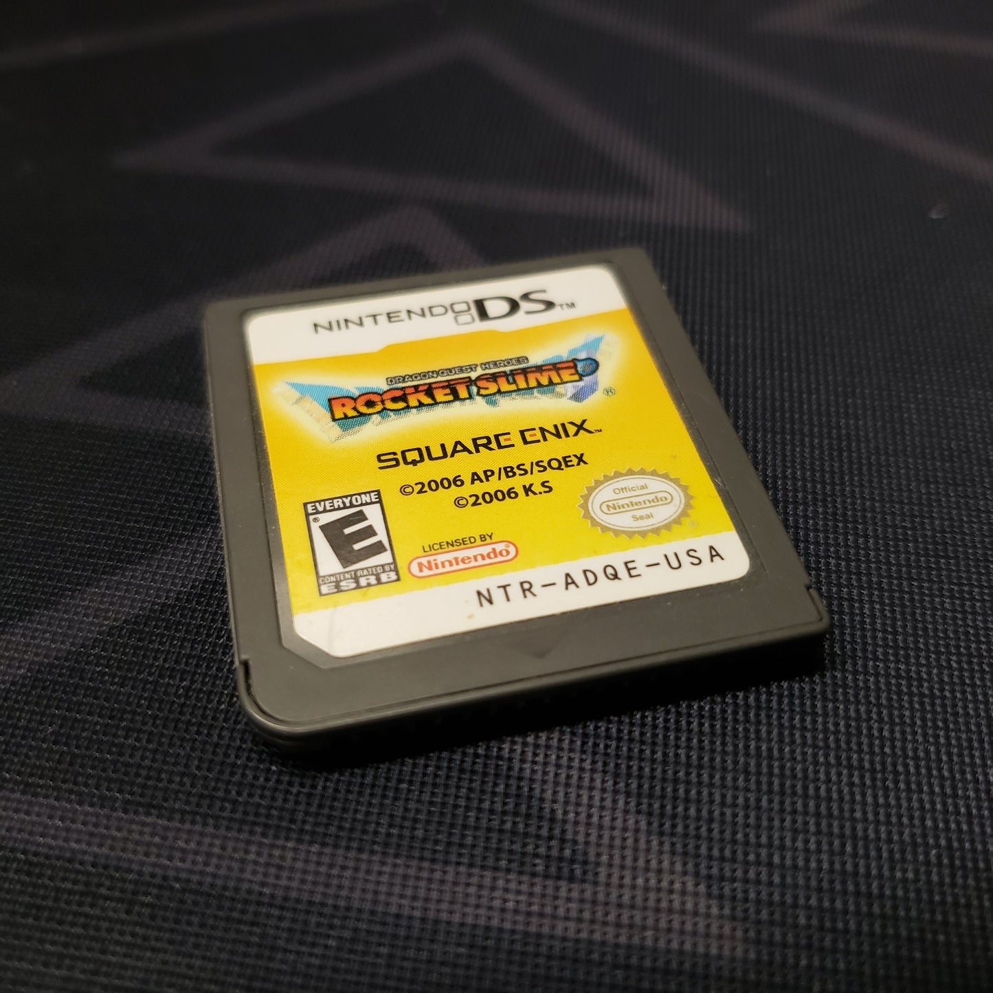 Image shows the front of the cartridge for the video game Dragon Quest Heroes: Rocket Slime for Nintendo DS