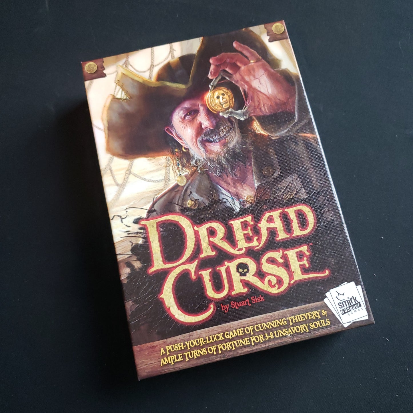 Image shows the front cover of the box of the Dread Curse card game