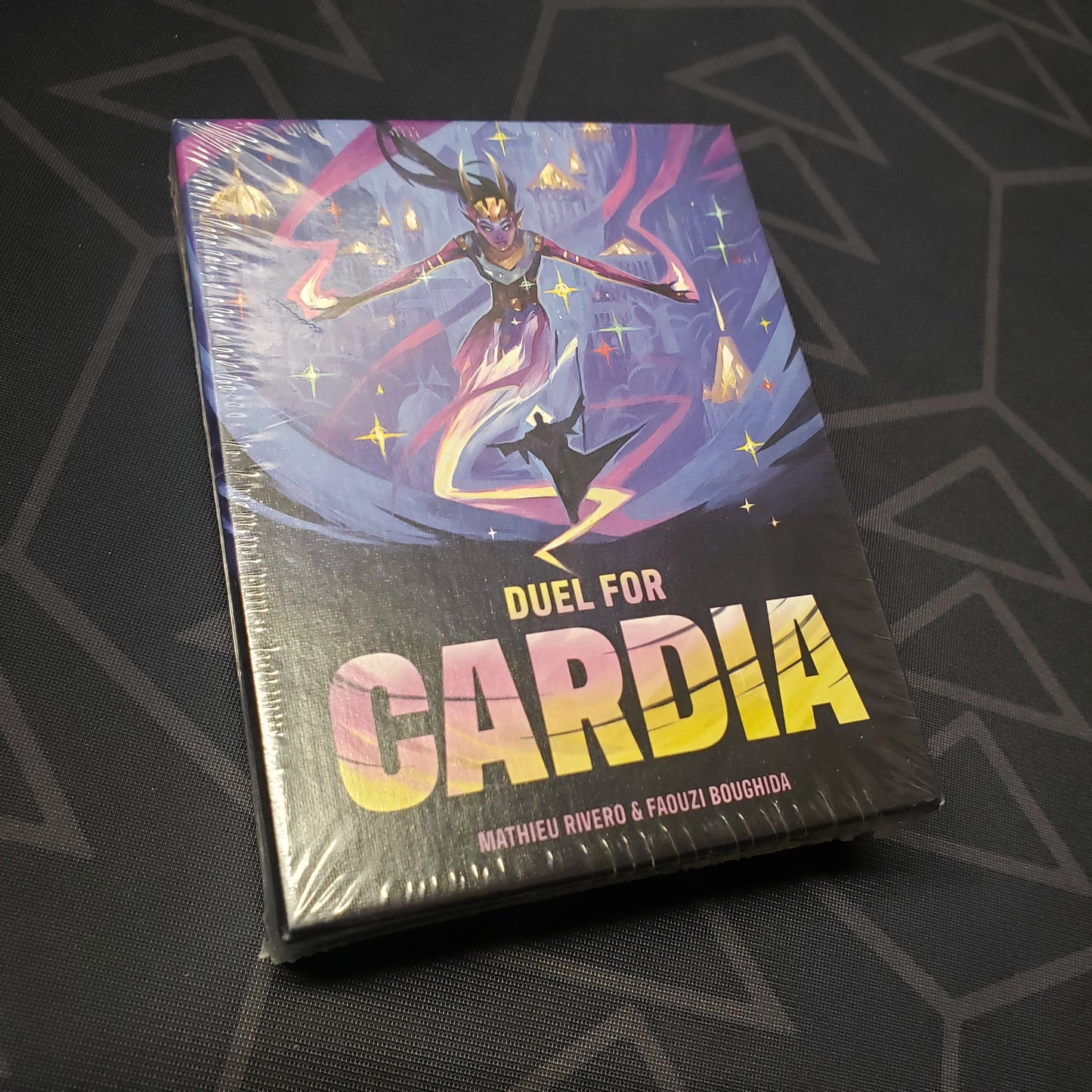 Image shows the front cover of the box for the Duel for Cardia card game