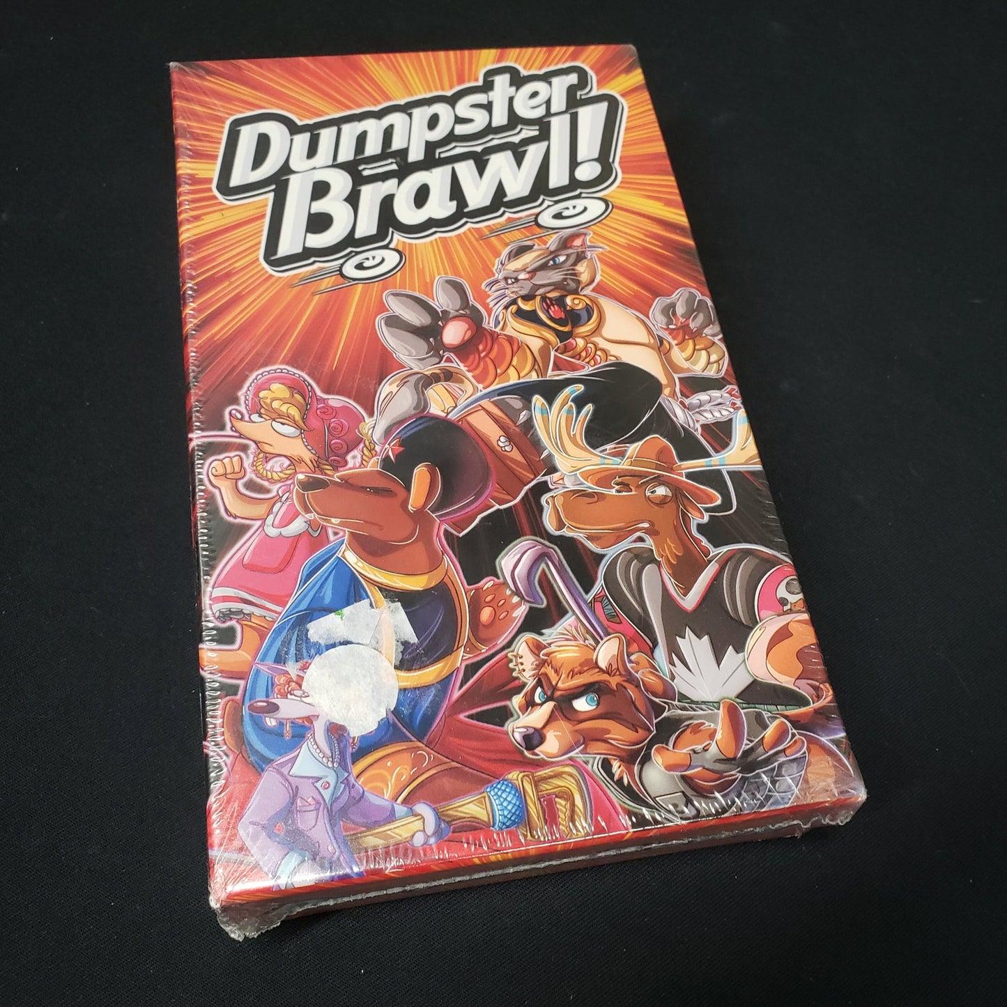 Image shows the front cover of the box of the Dumpster Brawl board game