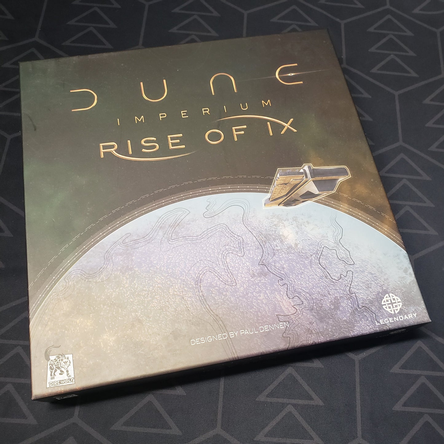 Image shows the front cover of the box of the Rise of Ix expansion for the board game Dune: Imperium