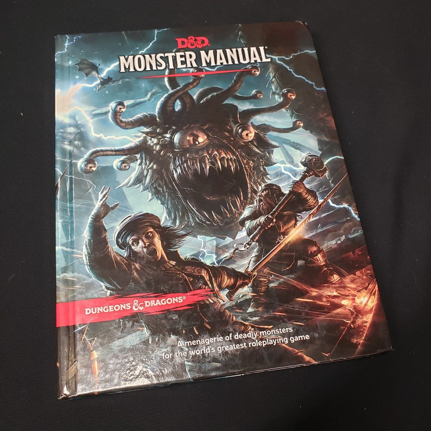 Image shows the front cover of the Monster Manual book for the roleplaying game Dungeons & Dragons: Fifth Edition