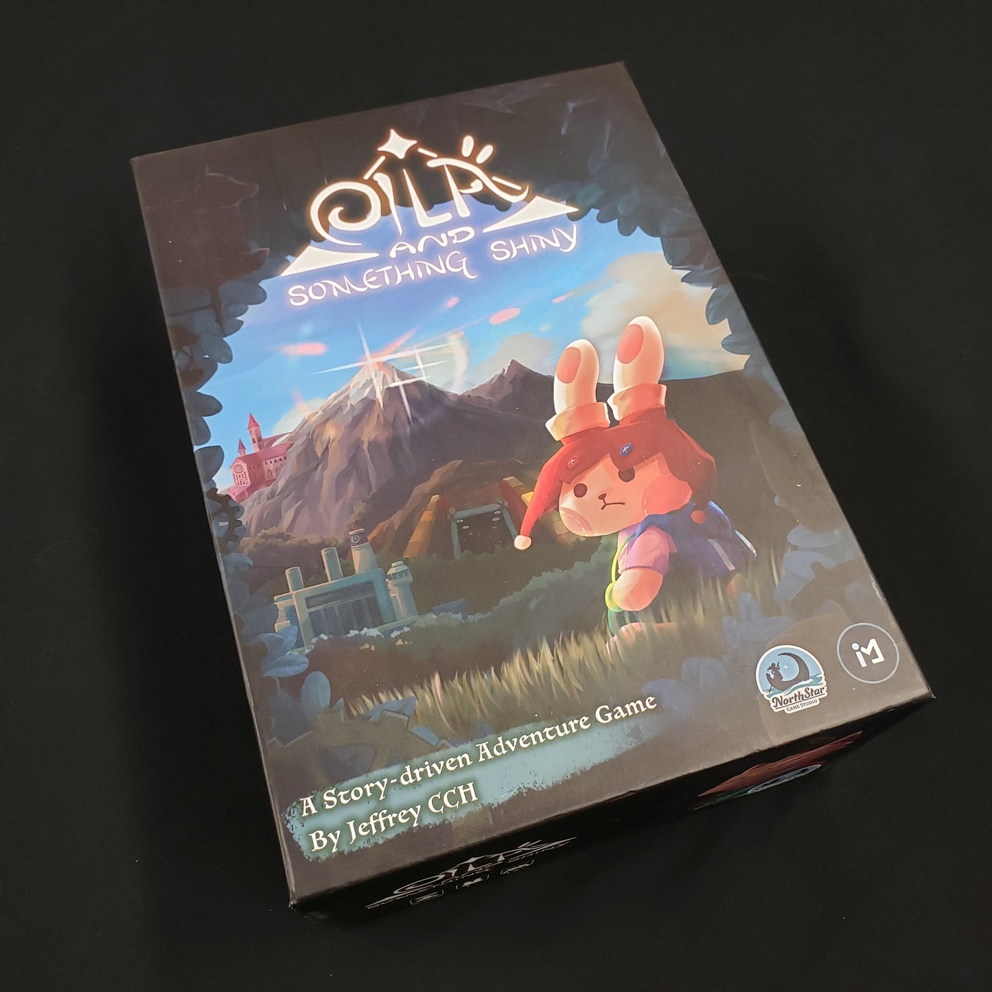 Image shows the front cover of the box of the Eila & Something Shiny board game