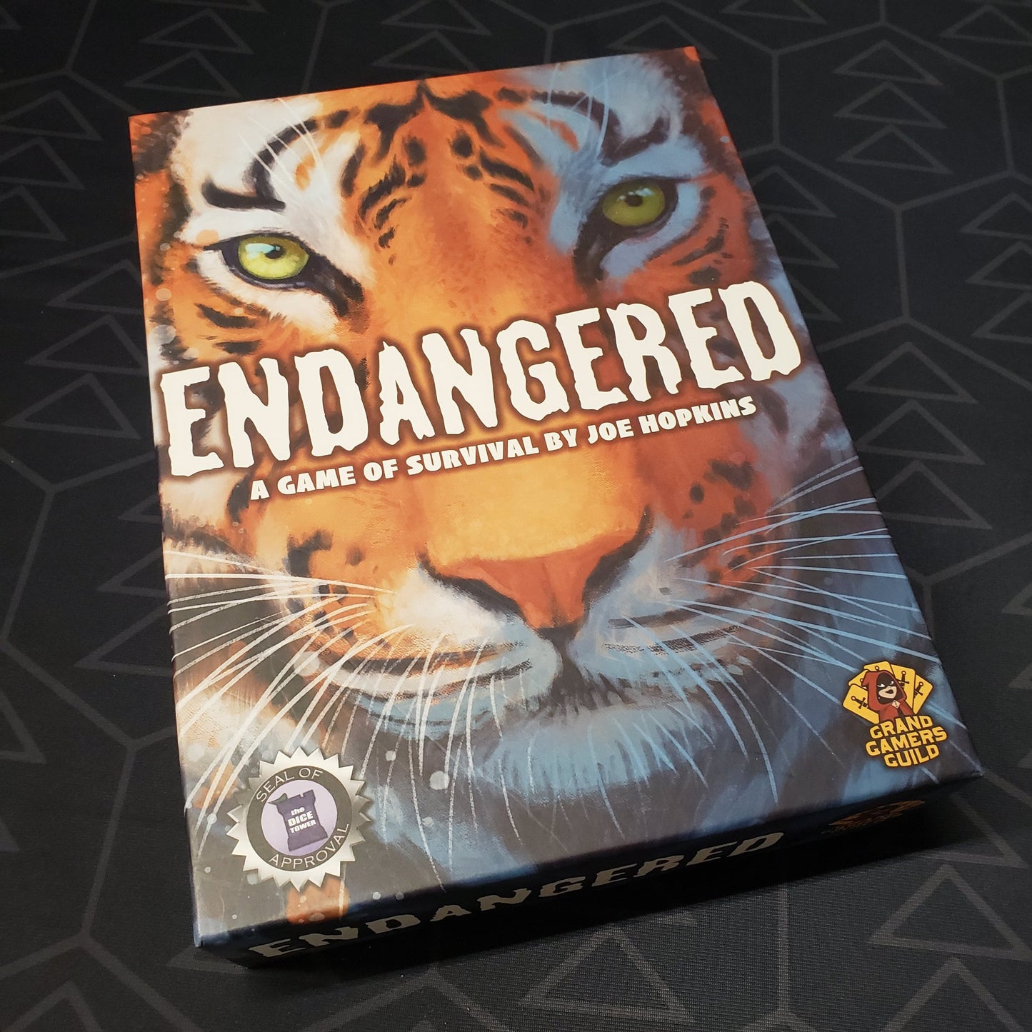 Image shows the front cover of the box of the Endangered board game