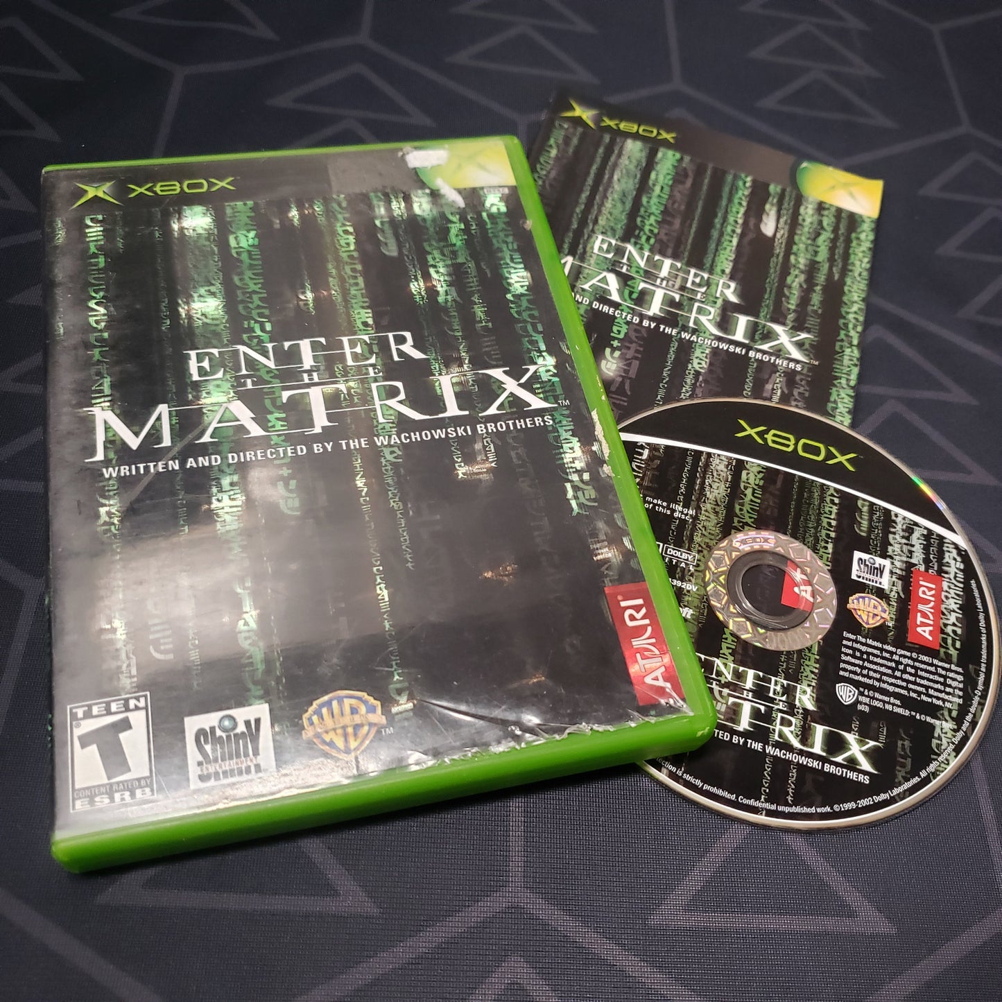 Image shows the case, manual and disc for the video game Enter the Matrix for the original Xbox