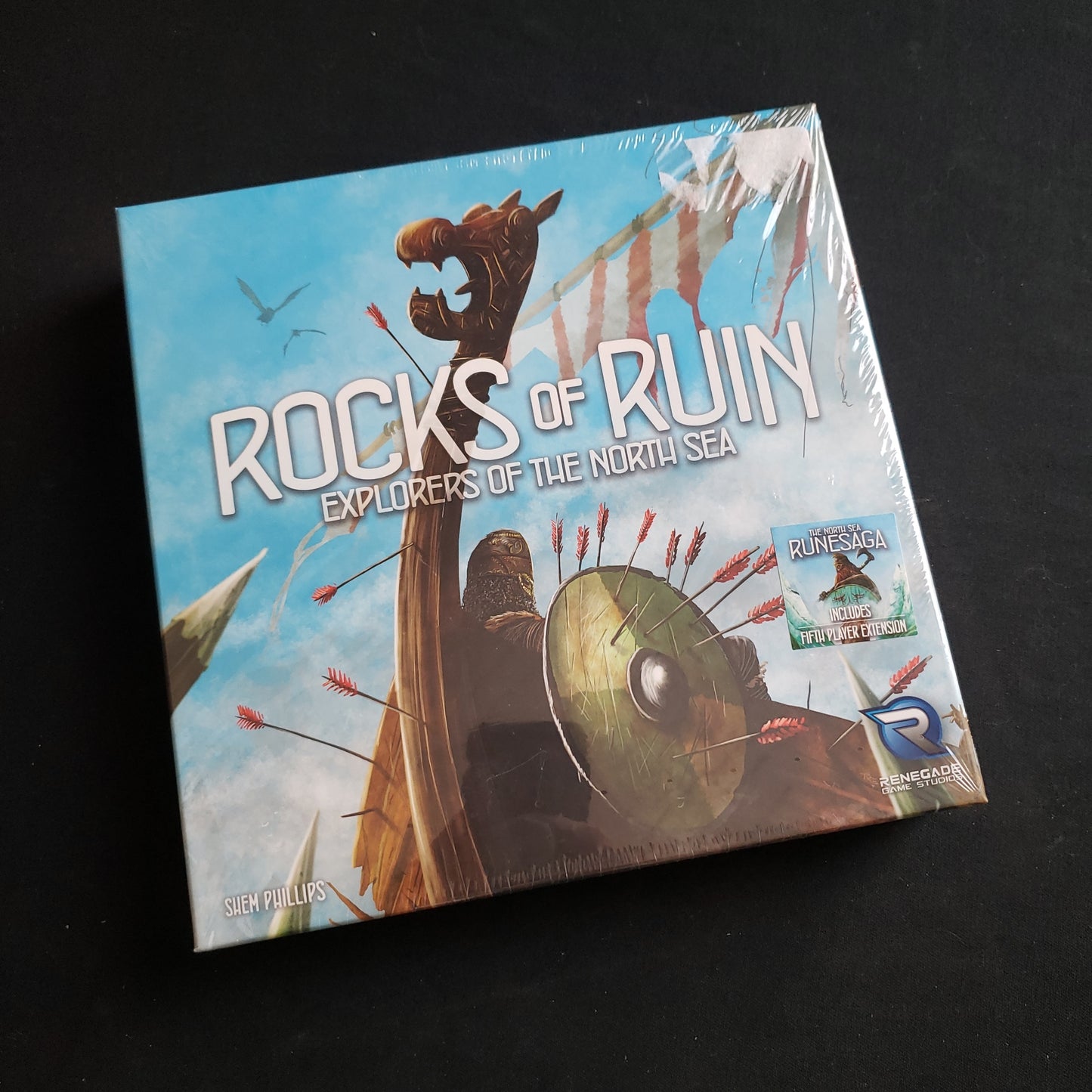 Image shows the front cover of the box of the Rocks of Ruin expansion for the board game Explorers of the North Sea