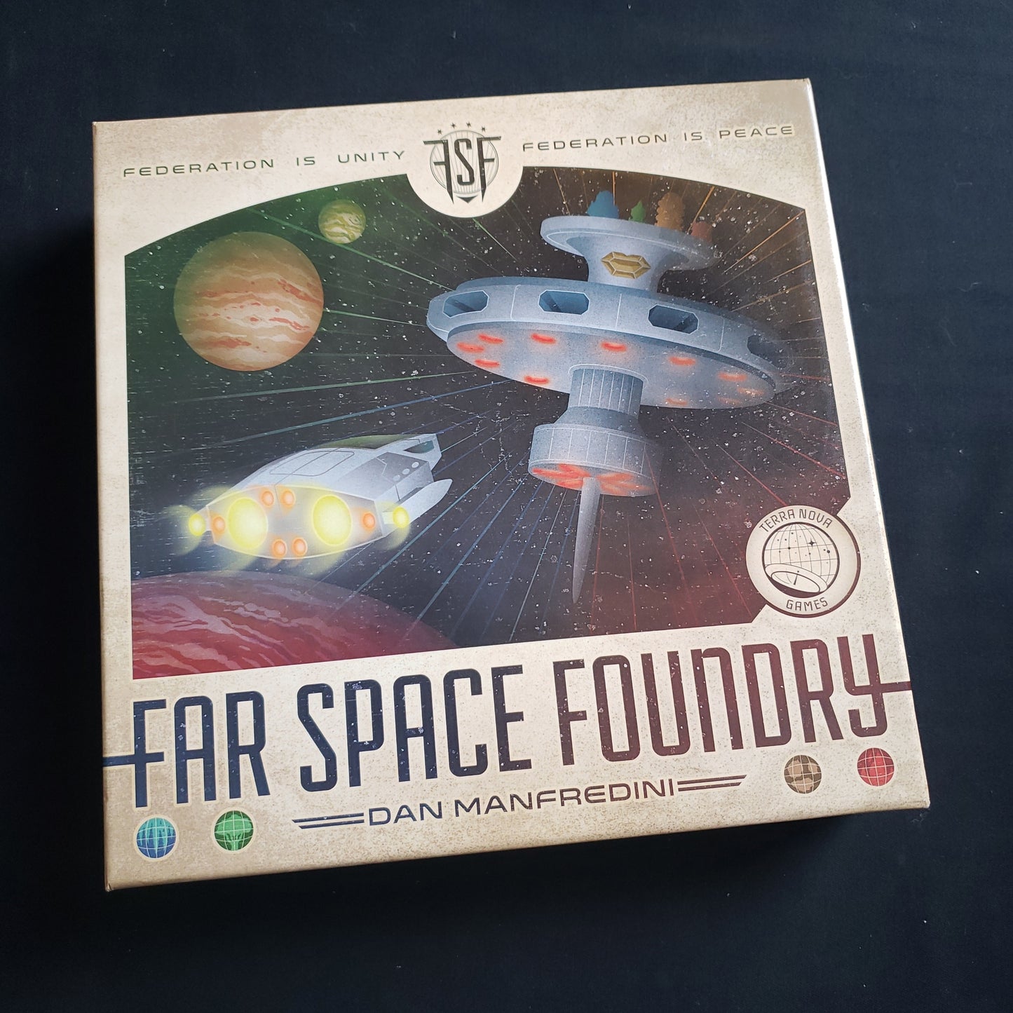 Image shows the front cover of the box of the Far Space Foundry board game