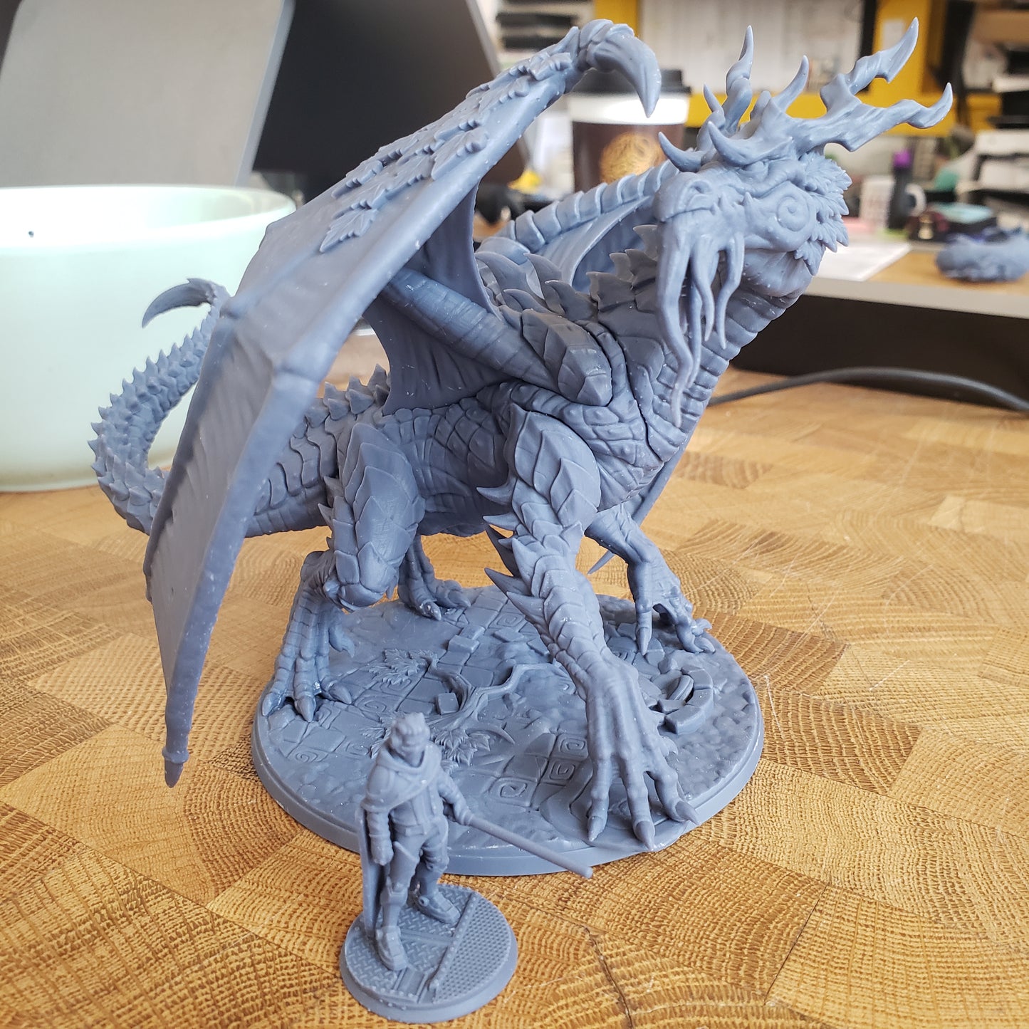 Image is a photo of a 3D printed forest dragon gaming miniature printed in-house at All Systems Go