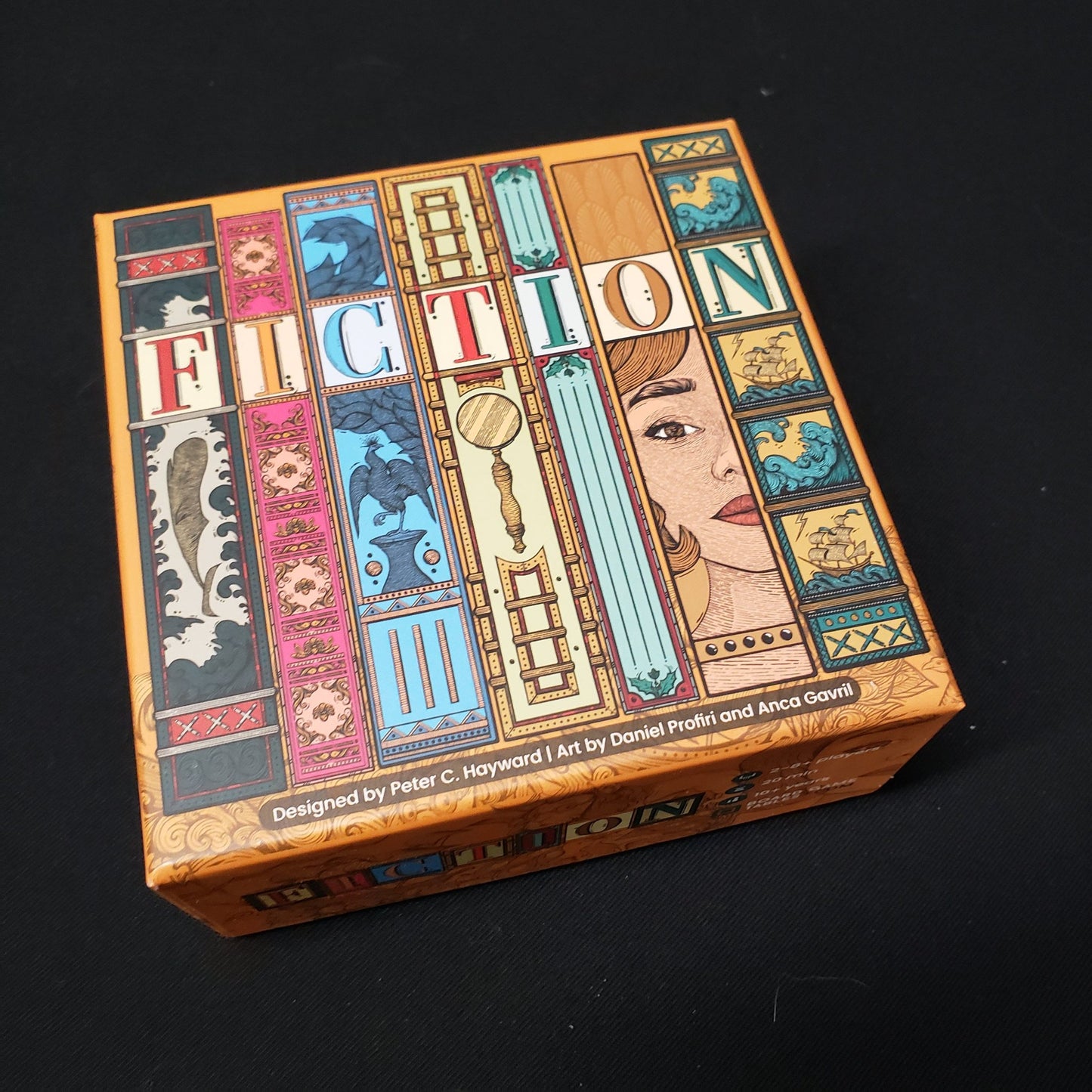 Image shows the front cover of the box of the Fiction board game