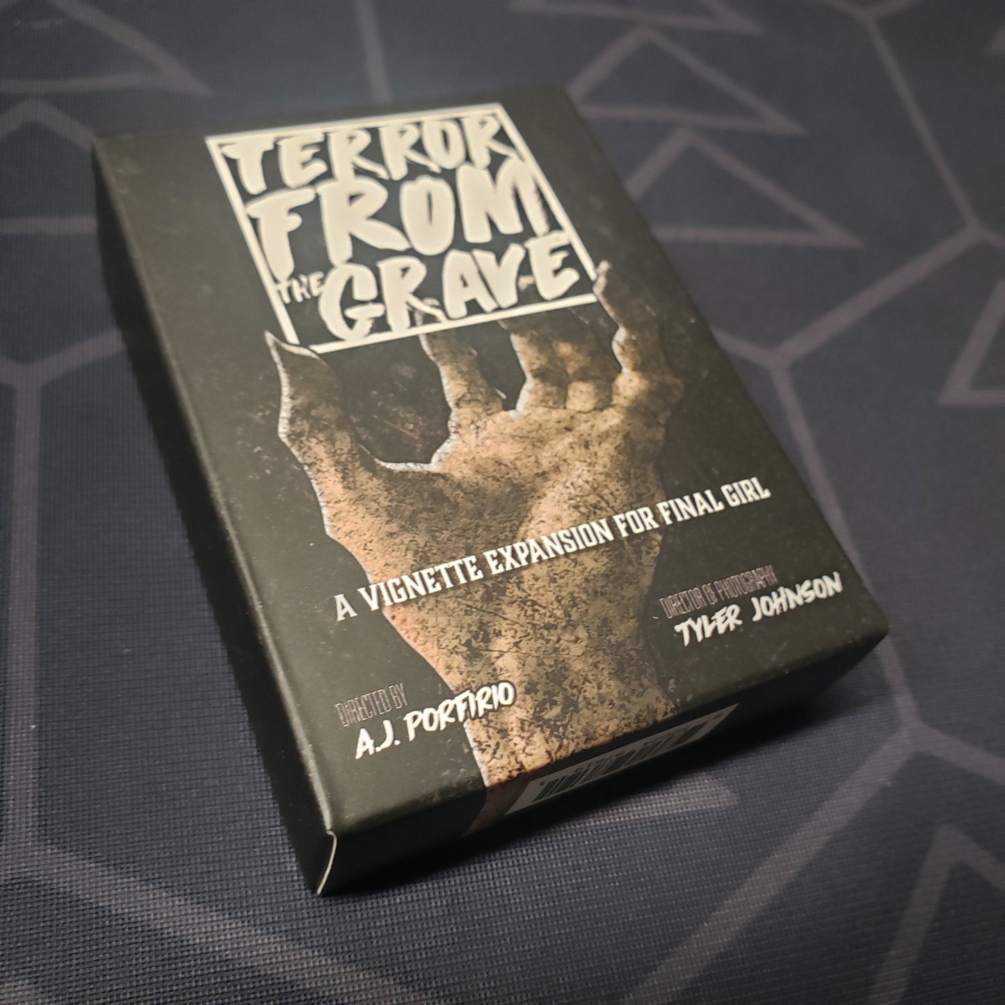 Image shows the front cover of the box of the Terror From The Grave Vignette expansion for the board game Final Girl