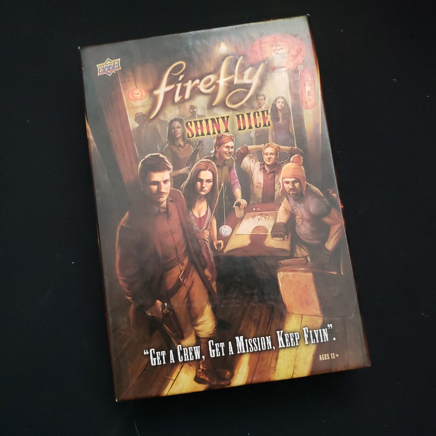 Image shows the front cover of the box of the Firefly: Shiny Dice board game