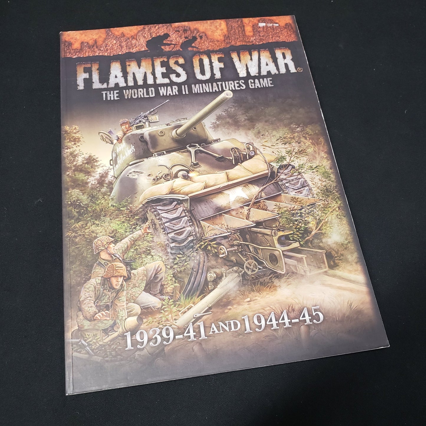 Image shows the front cover of the core rulebook for the miniatures game Flames of War