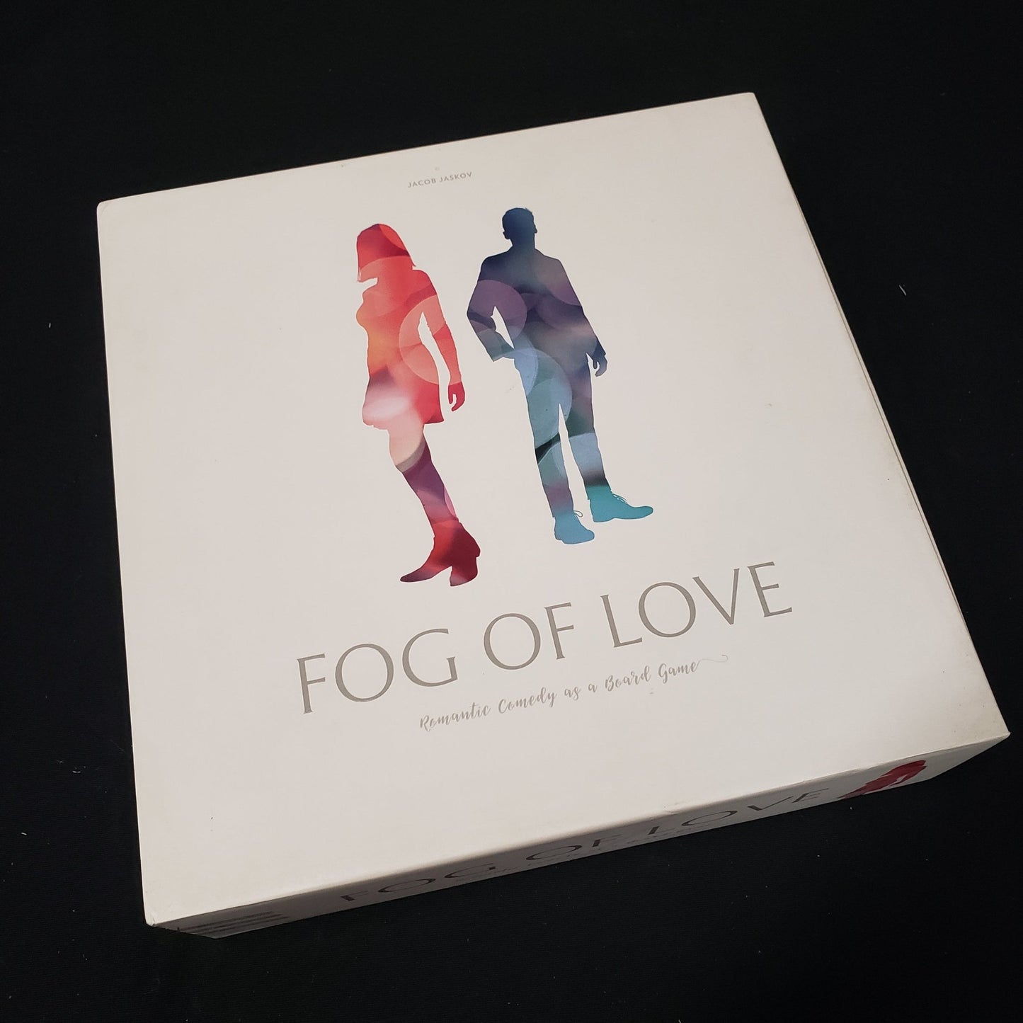 Image shows the front cover of the box of the Fog of Love board game