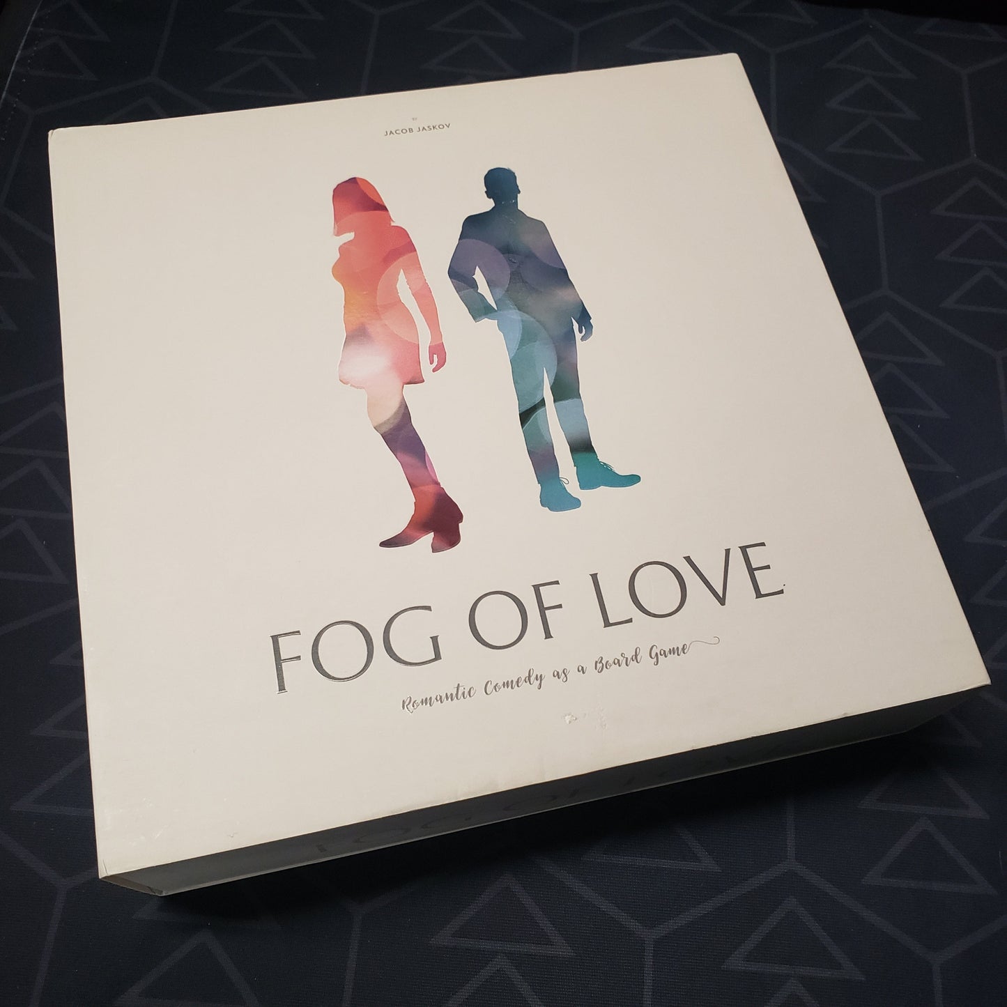 Image shows the front cover of the box of the Fog of Love board game