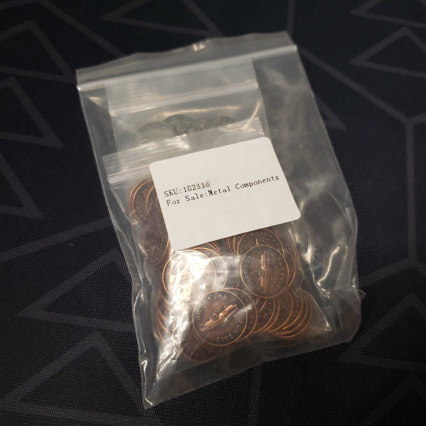 Image shows a baggie of metal coins for use with the board game For Sale