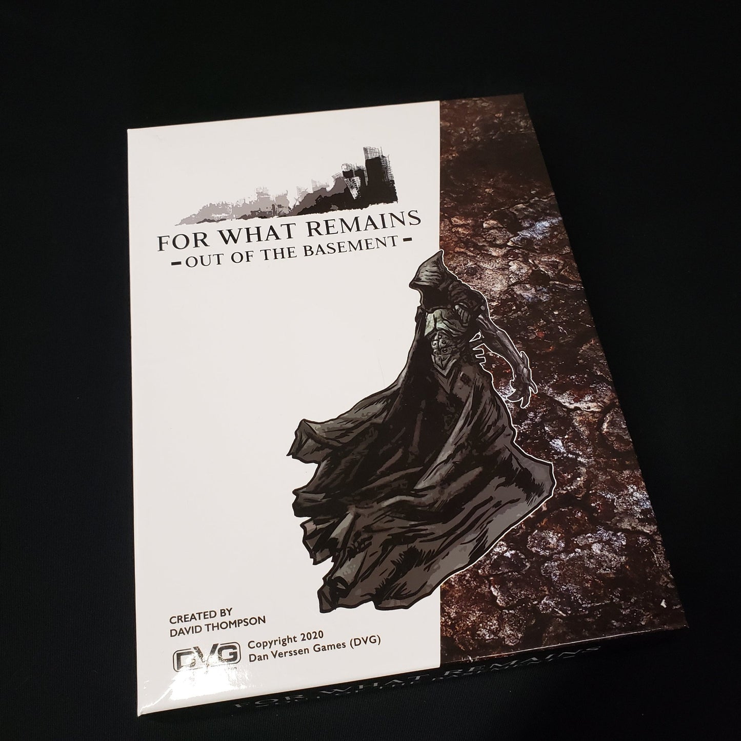 Image shows the front cover of the box of the board game for What Remains: Out of the Basement