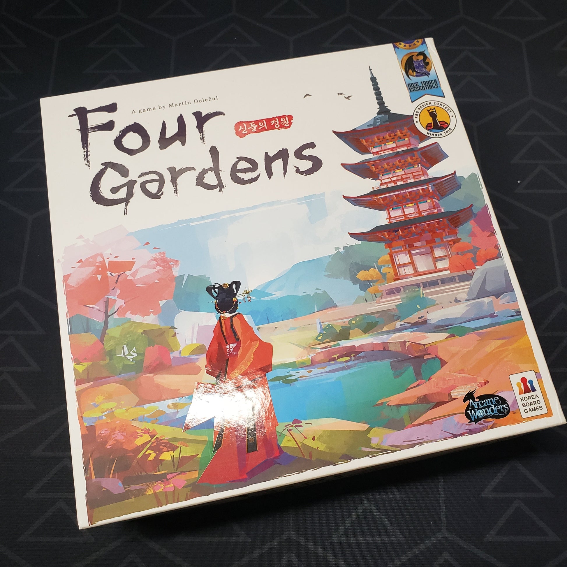 Image shows the front cover of the box for the Four Gardens board game