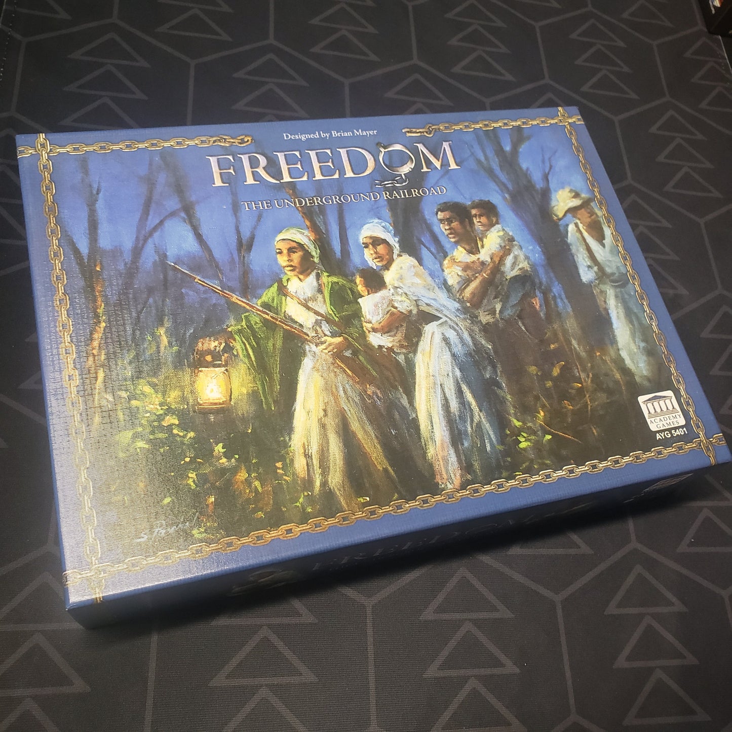 Image shows the front cover of the box of the Freedom: The Underground Railroad board game