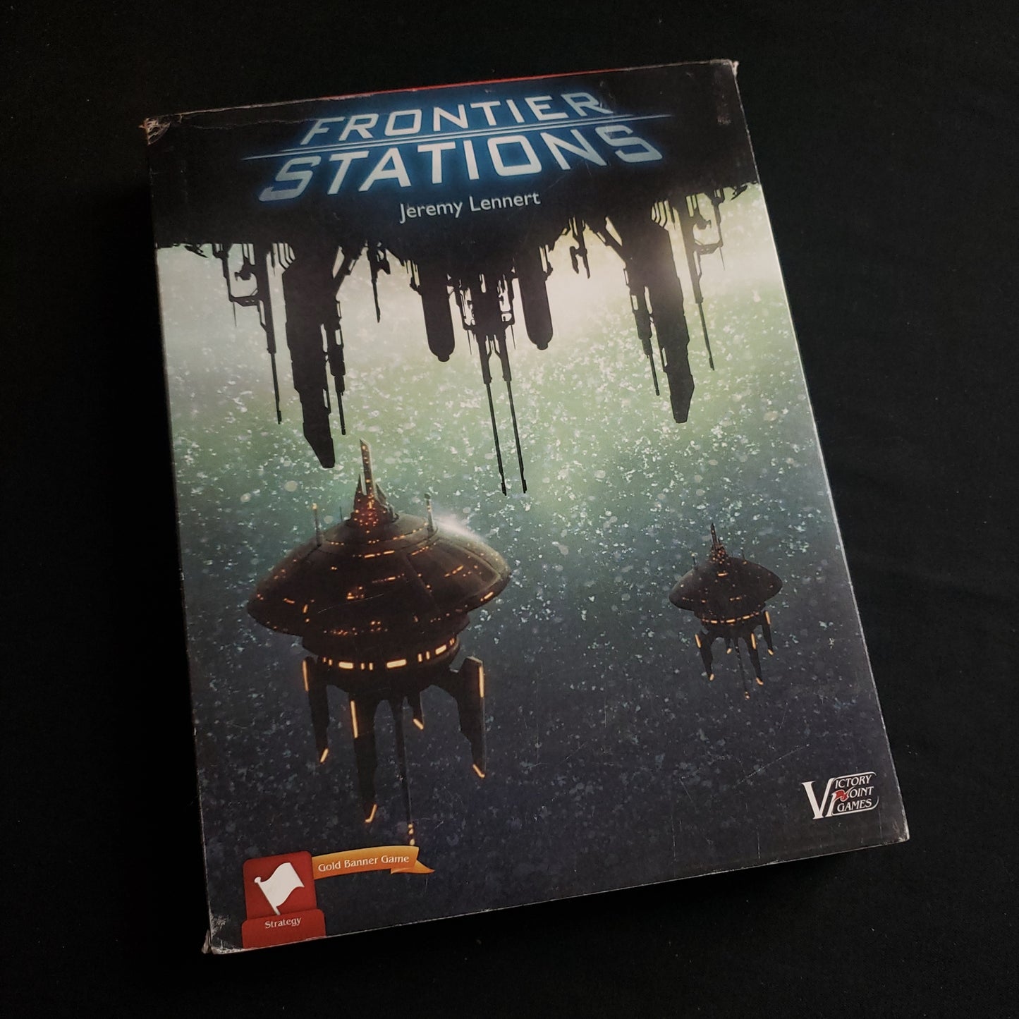 Image shows the front cover of the box of the Frontier Stations board game