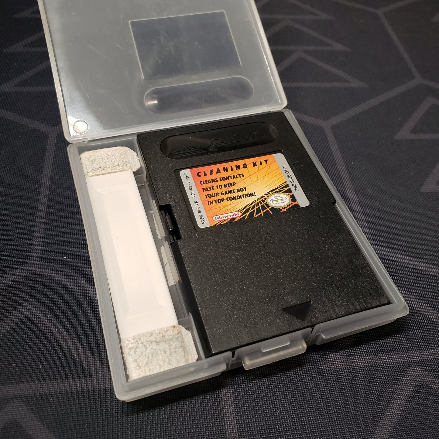 Image shows the front of the cartridge & brush for the official Gameboy Cleaning Kit for Nintendo Game Boy sitting in an open clear plastic case