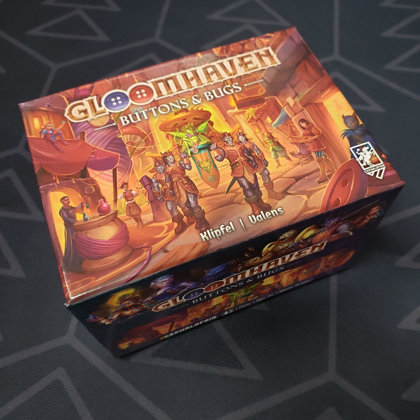 Image shows the front cover of the box for the Gloomhaven: Buttons & Bugs board game