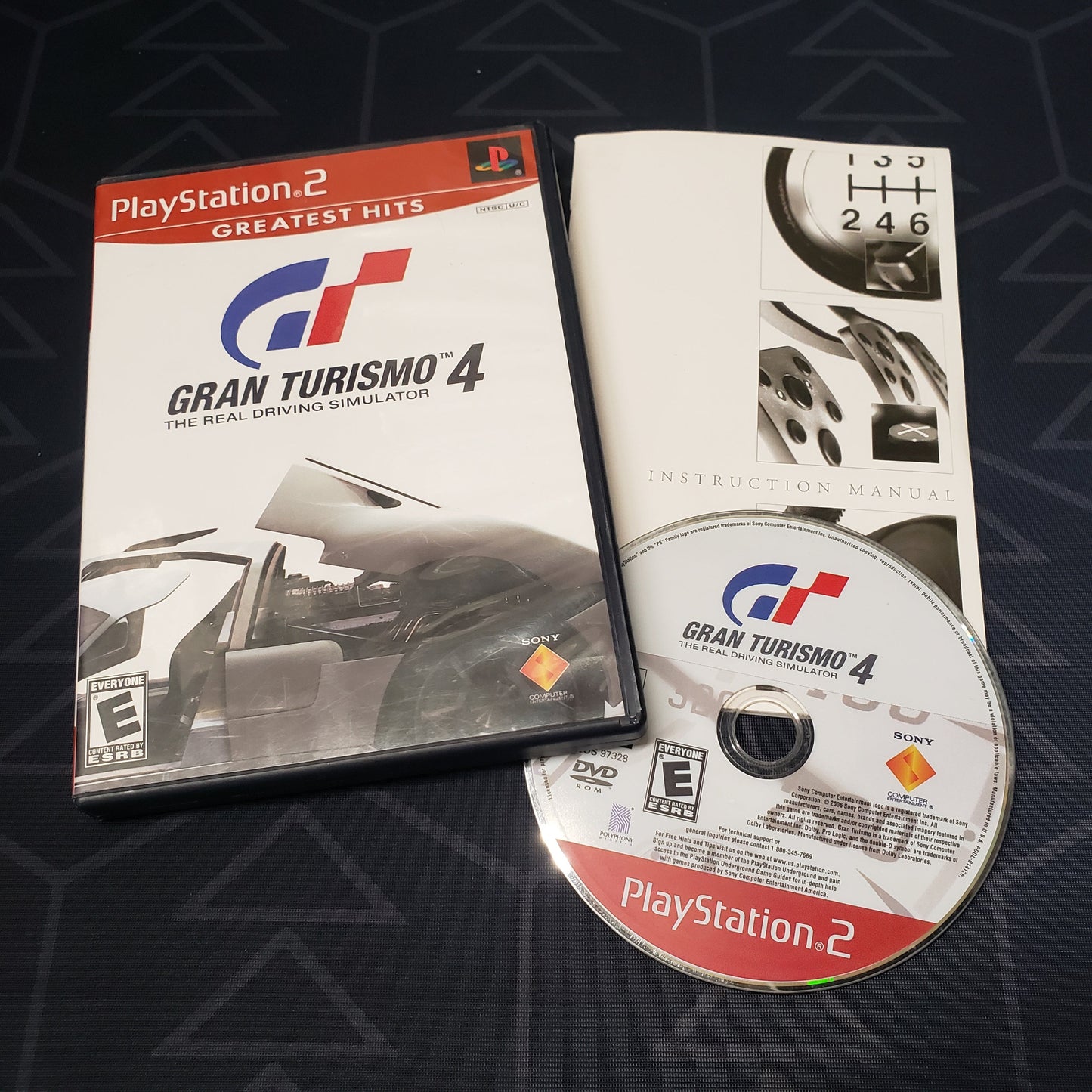 Image shows the case, manual & disc for the video game Gran Turismo 4 for Playstation 2