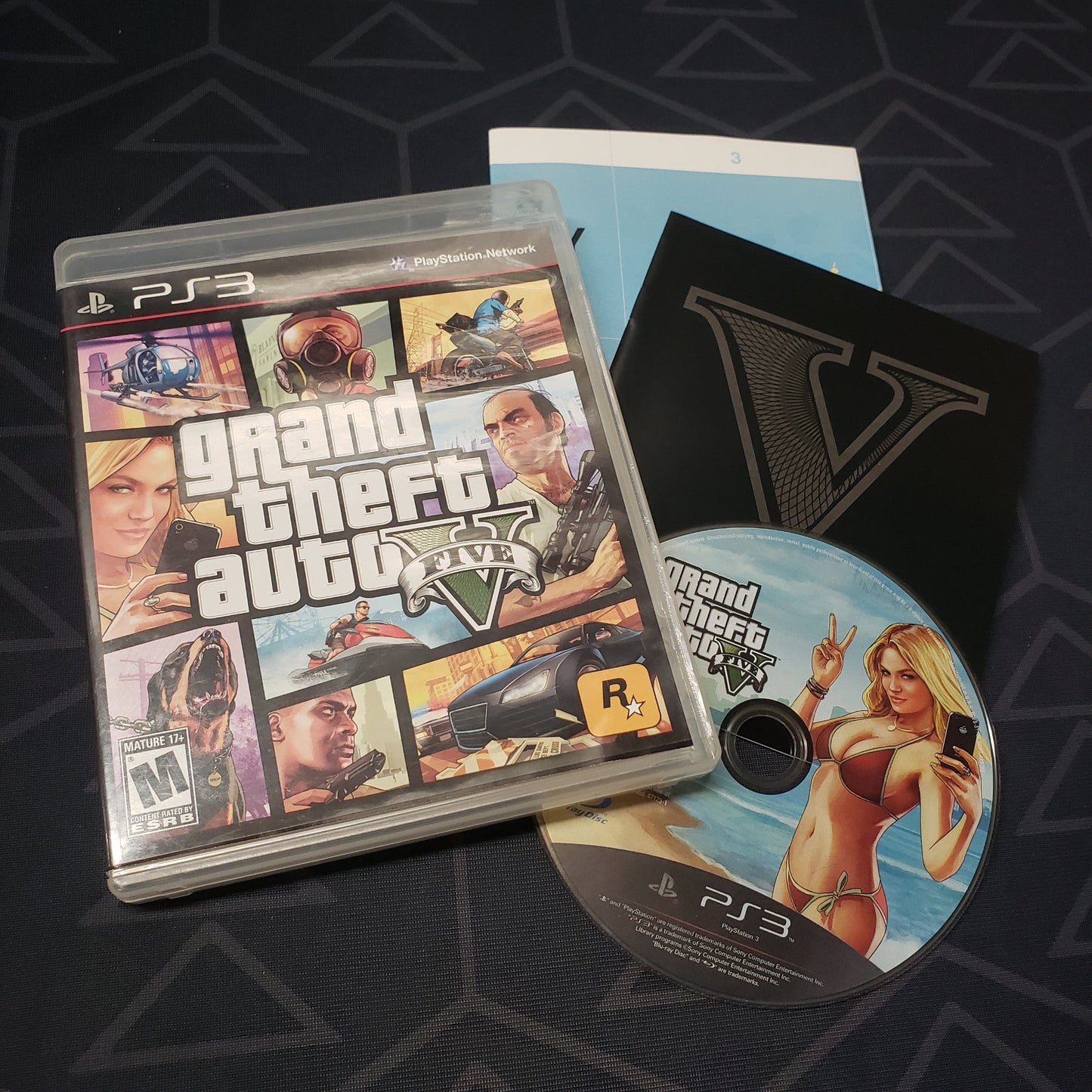 Image shows the case, manual, map and disc for the video game Grand Theft Auto V for Playstation 3