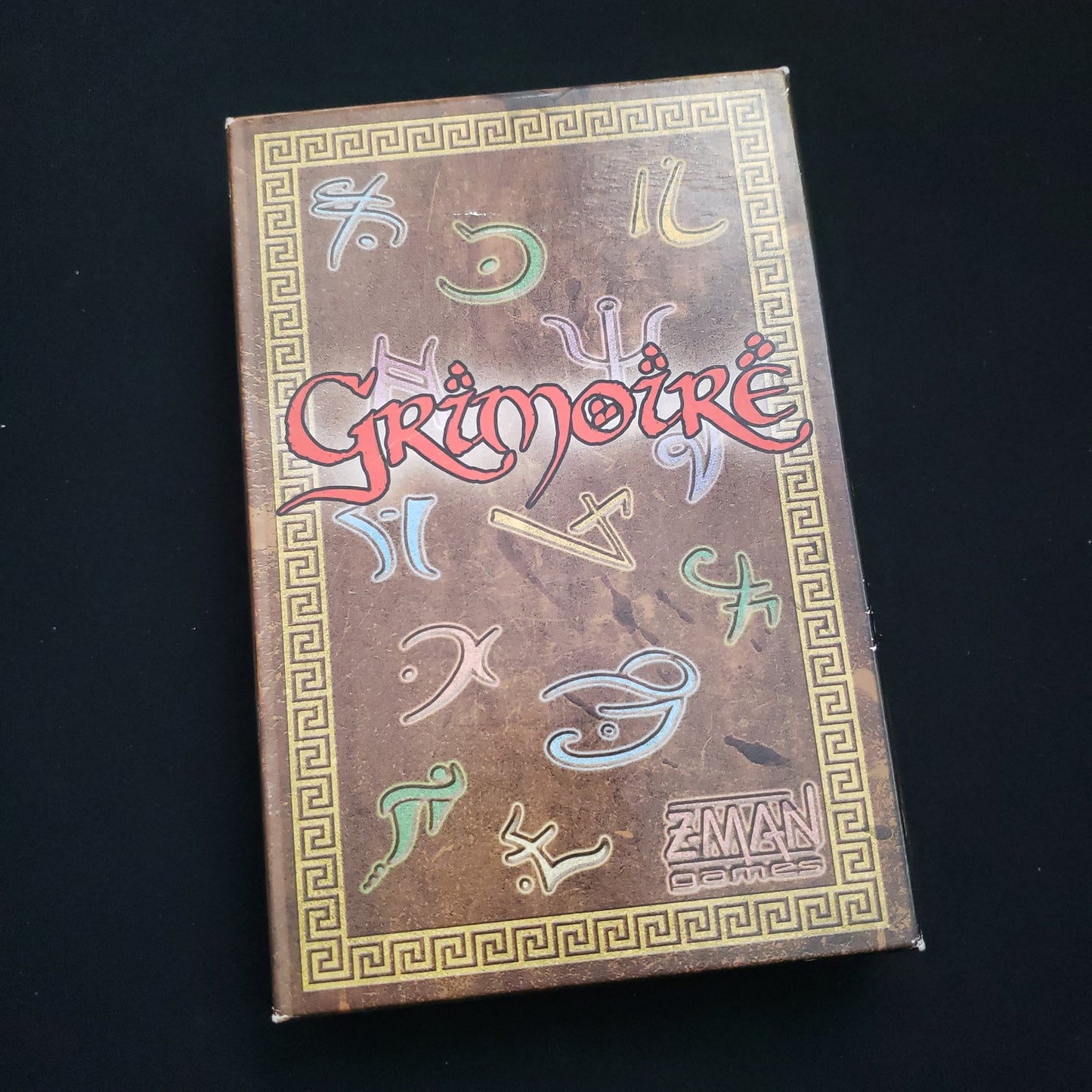 Image shows the front cover of the box of the Grimoire card game