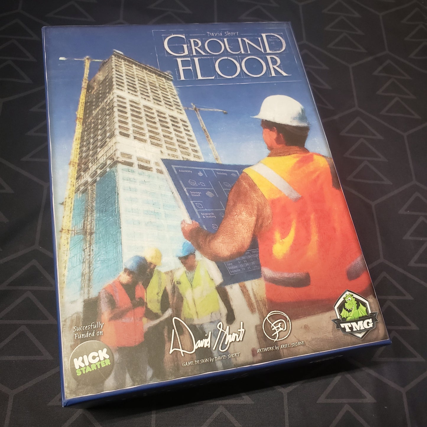 Image shows the front cover of the box of the Ground Floor board game