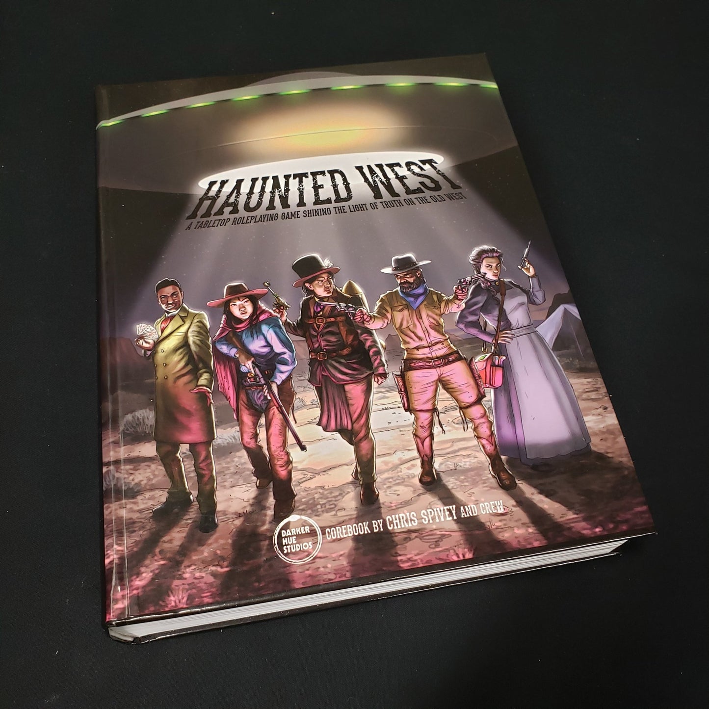 Image shows the front cover of the core rulebook for the roleplaying game Haunted West