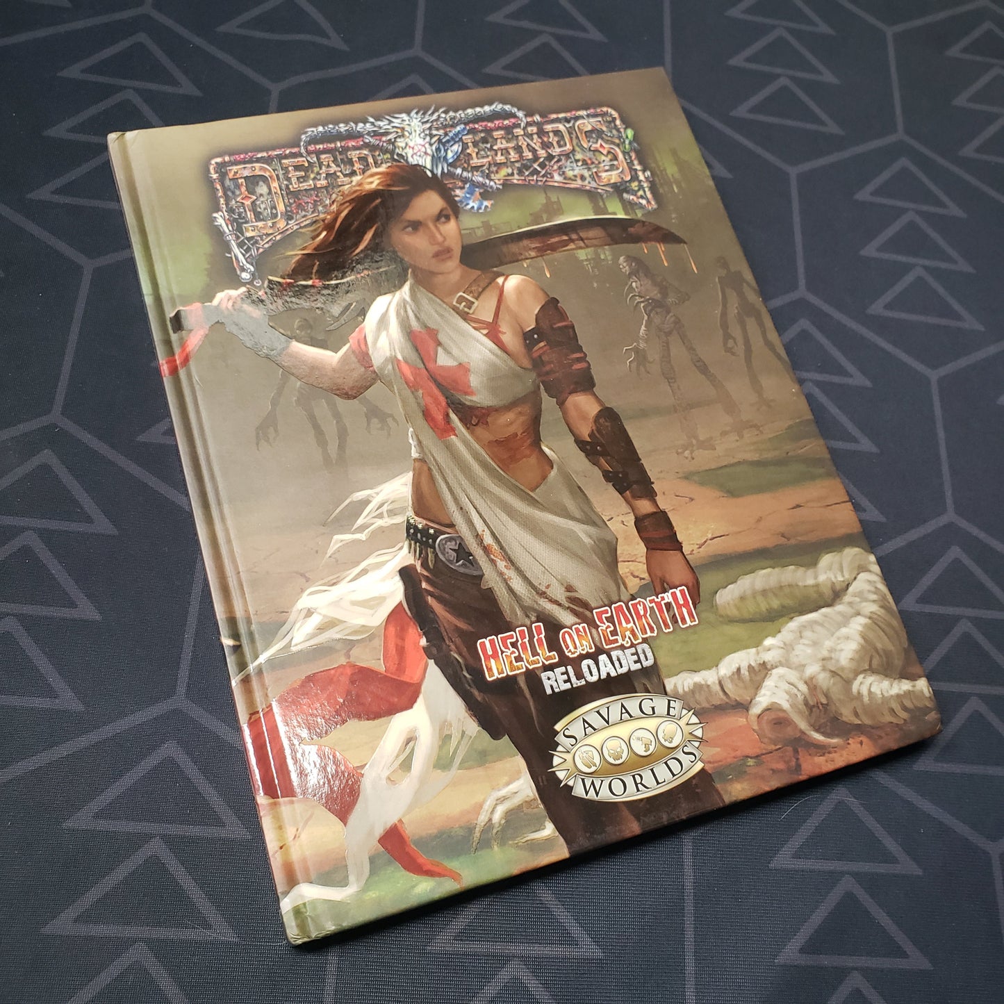 Image shows the front cover of the core rulebook for the roleplaying game Hell on Earth: Reloaded