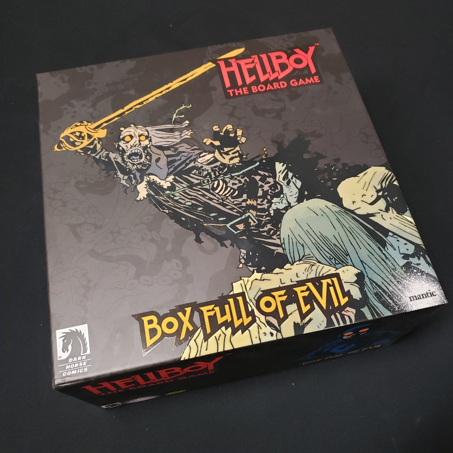 Image shows the front cover of the box of the Box Full of Evil expansion for Hellboy: The Board Game