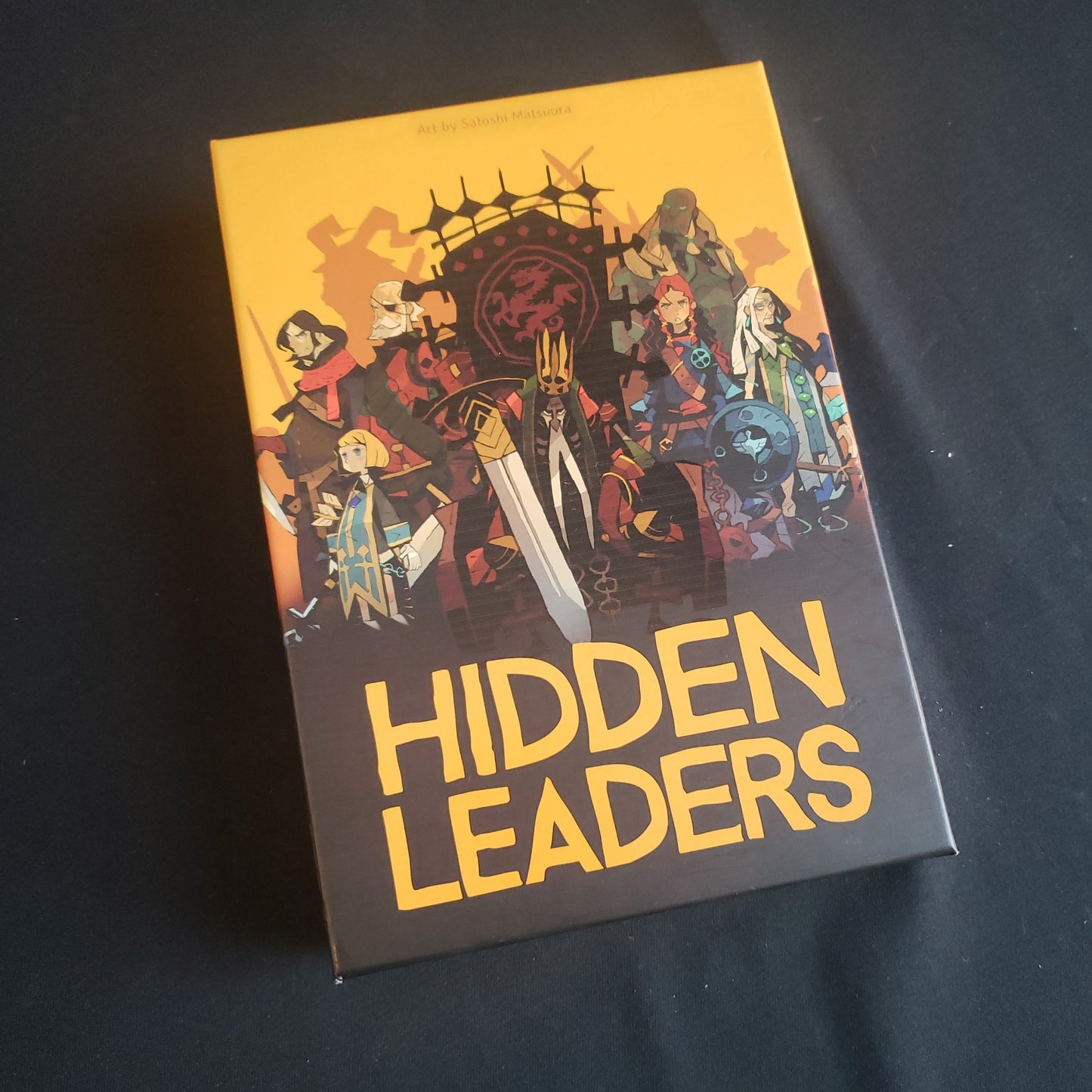 Image shows the front cover of the box of the Hidden Leaders card game