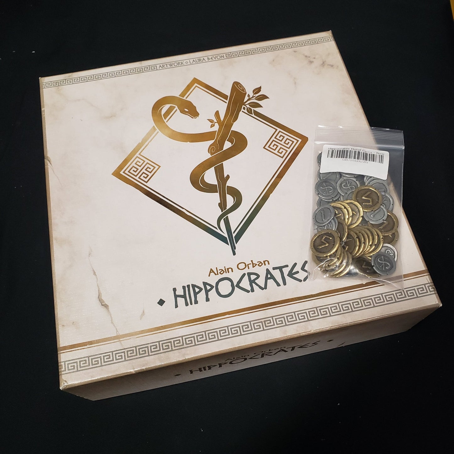 Image shows the front cover of the box of the Hippocrates board game with the Metal Coin pack sitting on top of it