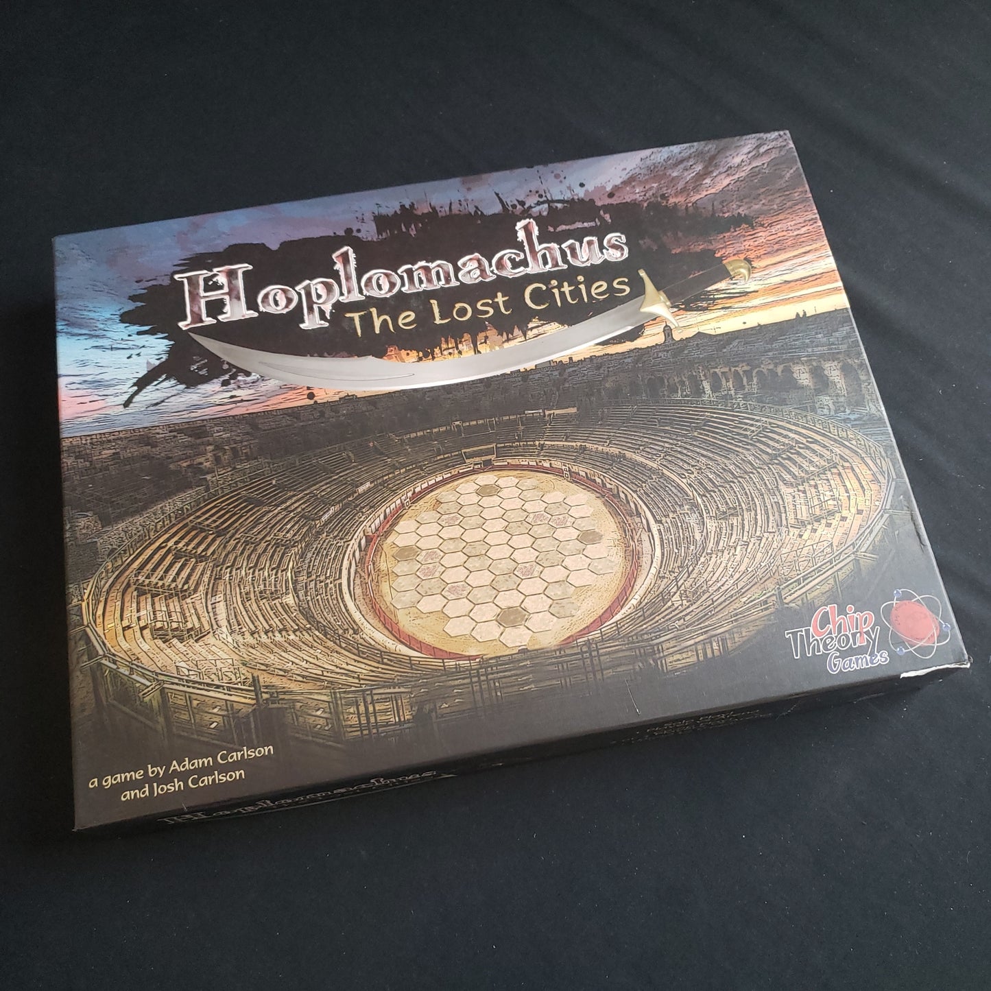 Image shows the front cover of the box of the Hoplomachus: The Lost Cities board game