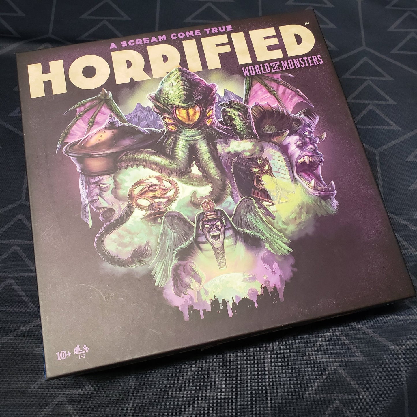 Image shows the front cover of the box of the Horrified: World of Monsters board game