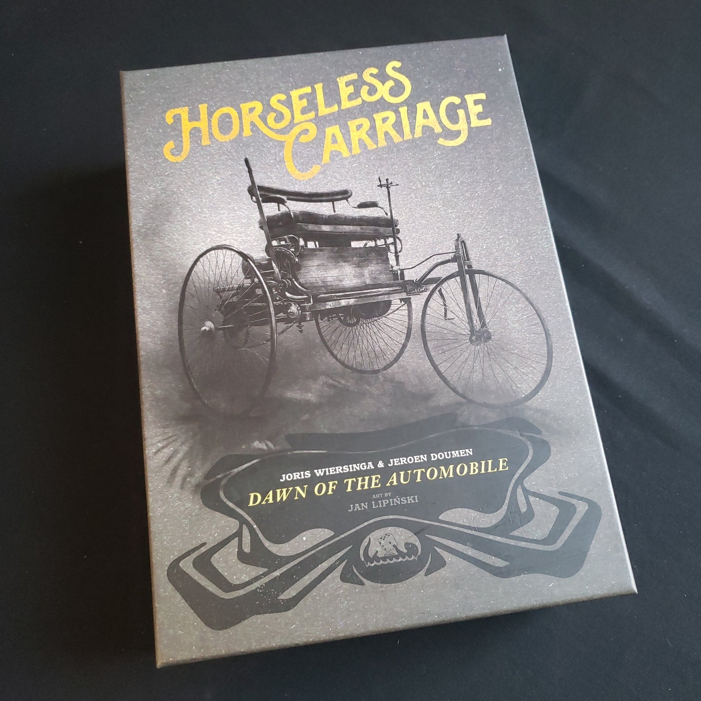 Image shows the front cover of the box of the Horseless Carriage board game