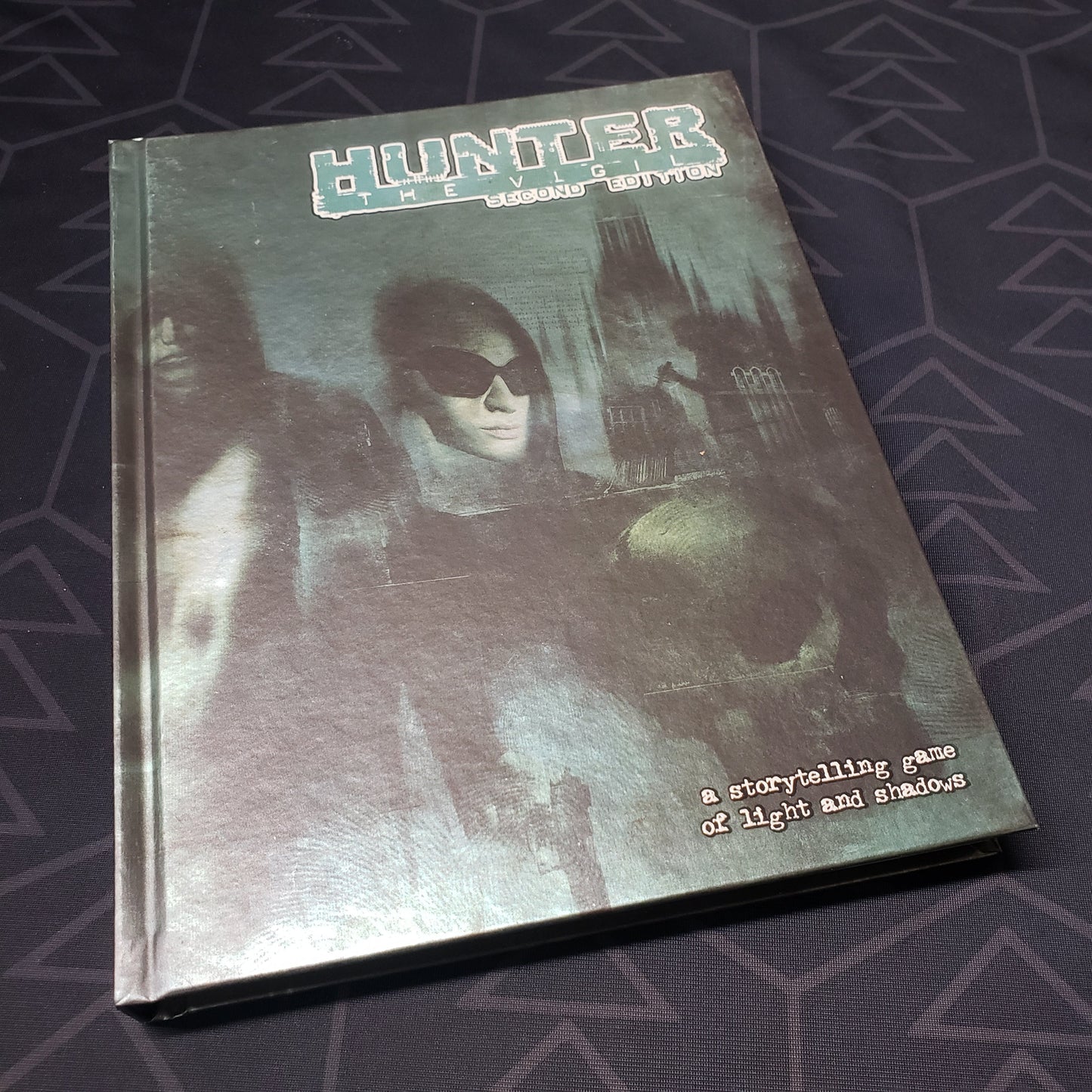 Image shows the front cover of the second edition core rulebook for the roleplaying game Hunter: The Vigil