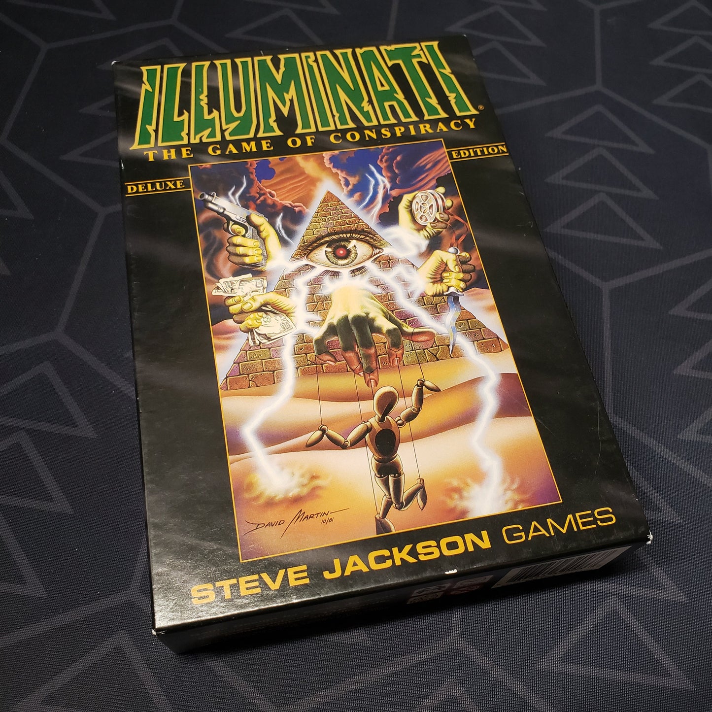 Image shows the front cover of the box of the Illuminati card game