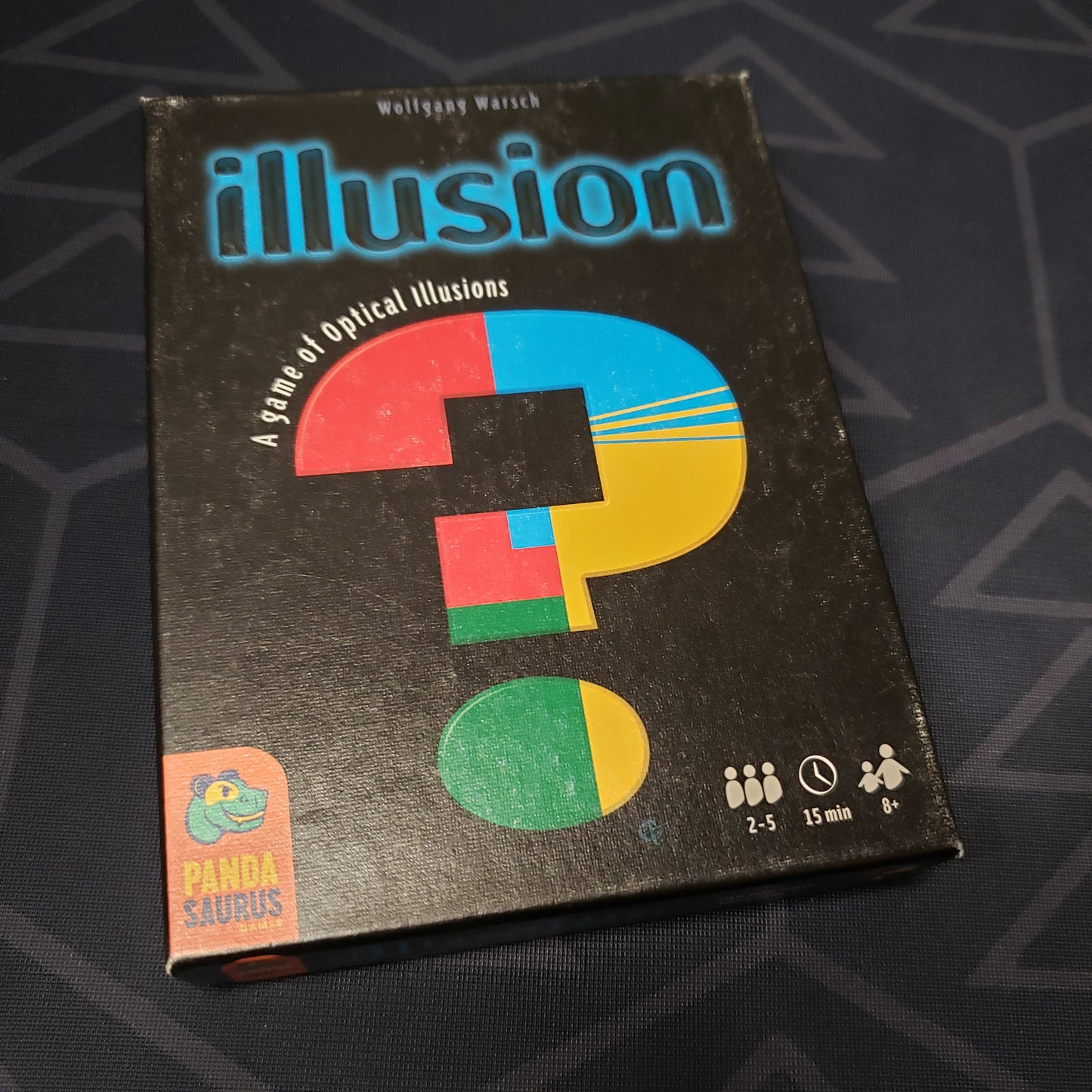 Image shows the front cover of the box for the Illusion card game