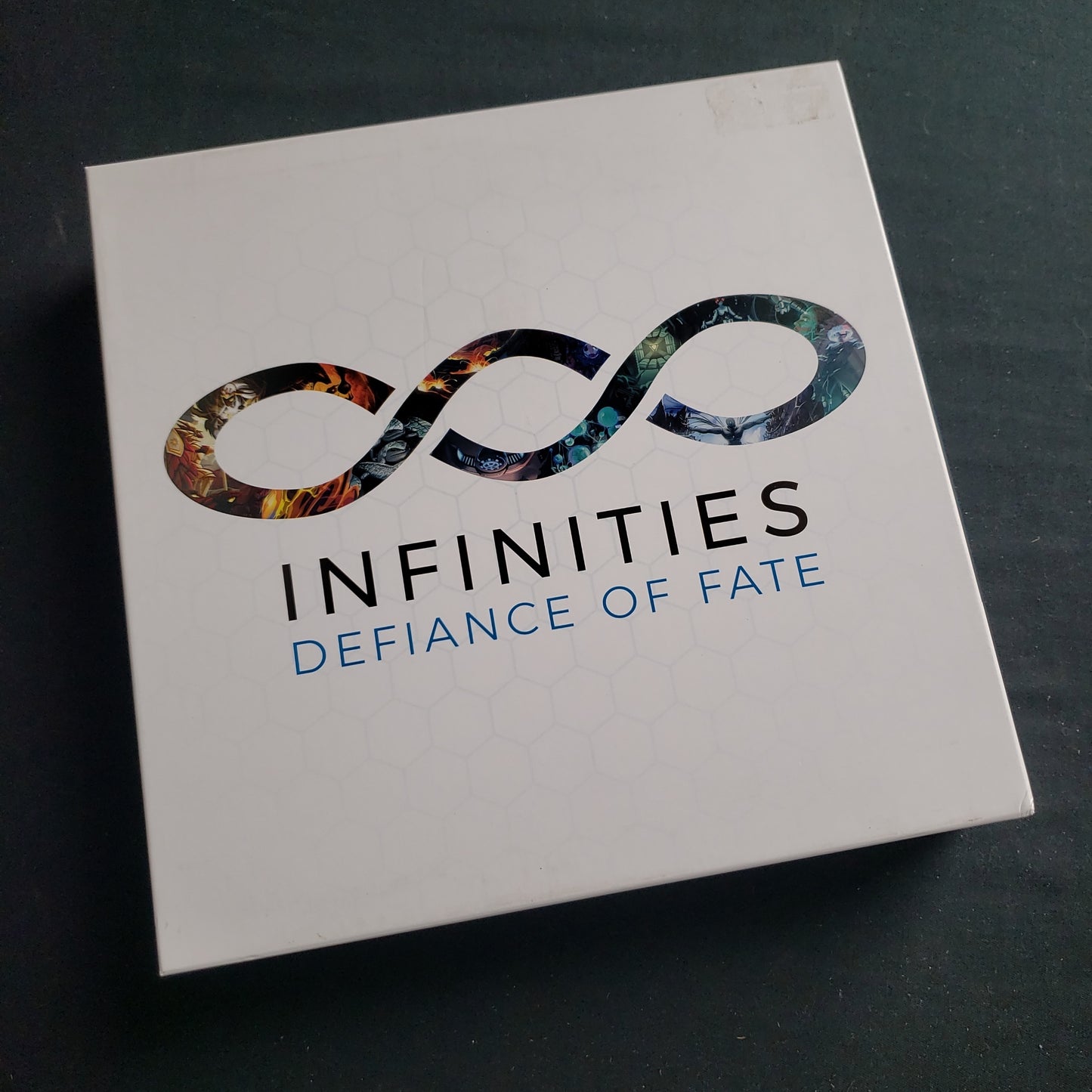 Image shows the front cover of the box of the Infinities: Defiance of Fate board game